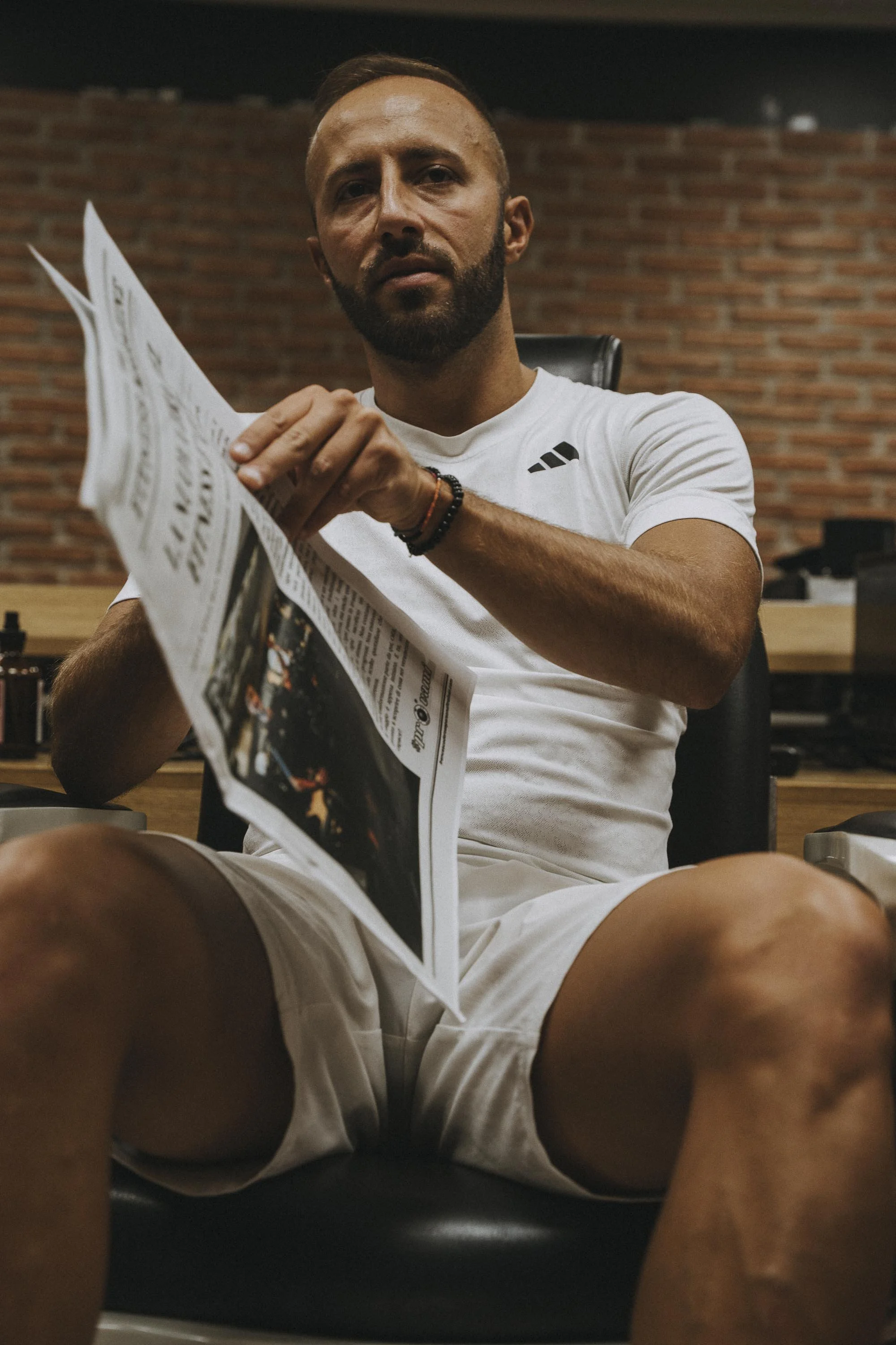 Uomo seduto in ufficio che legge un giornale.