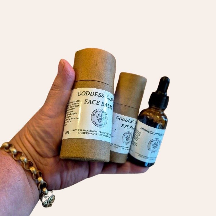 The Ritual Set held in a hand — Goddess Glow Face Balm, Goddess Glow Eye Balm and Goddess Ritual Face Oil