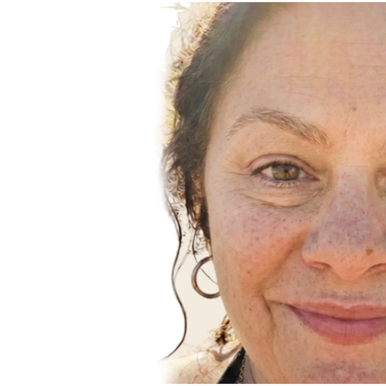 Close-up of the face of a woman in her sixties, freckled skin, curly hair and a gold hoop earring