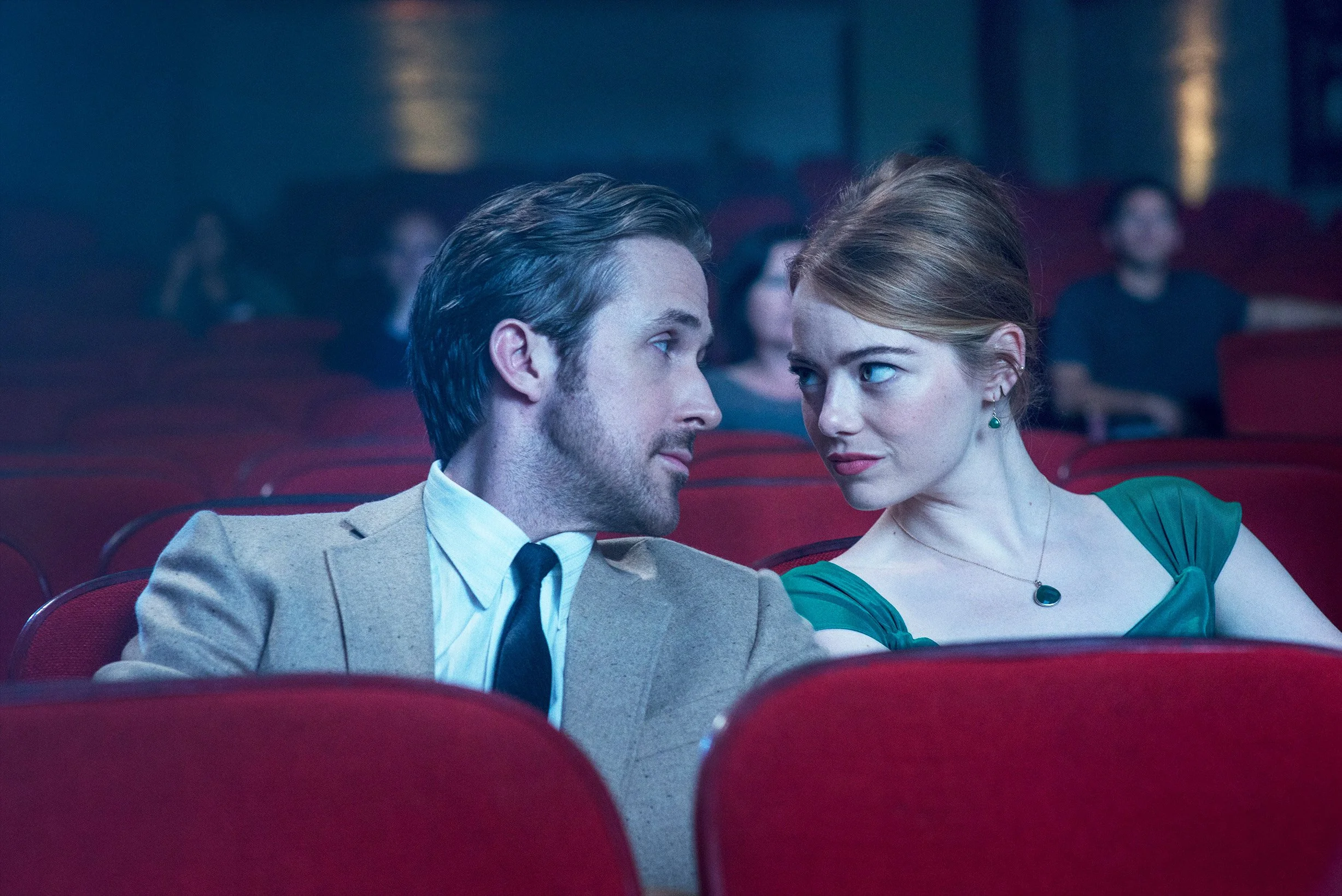 Ryan Gosling and Emma Stone sit in a movie theater on the set of La La Land.