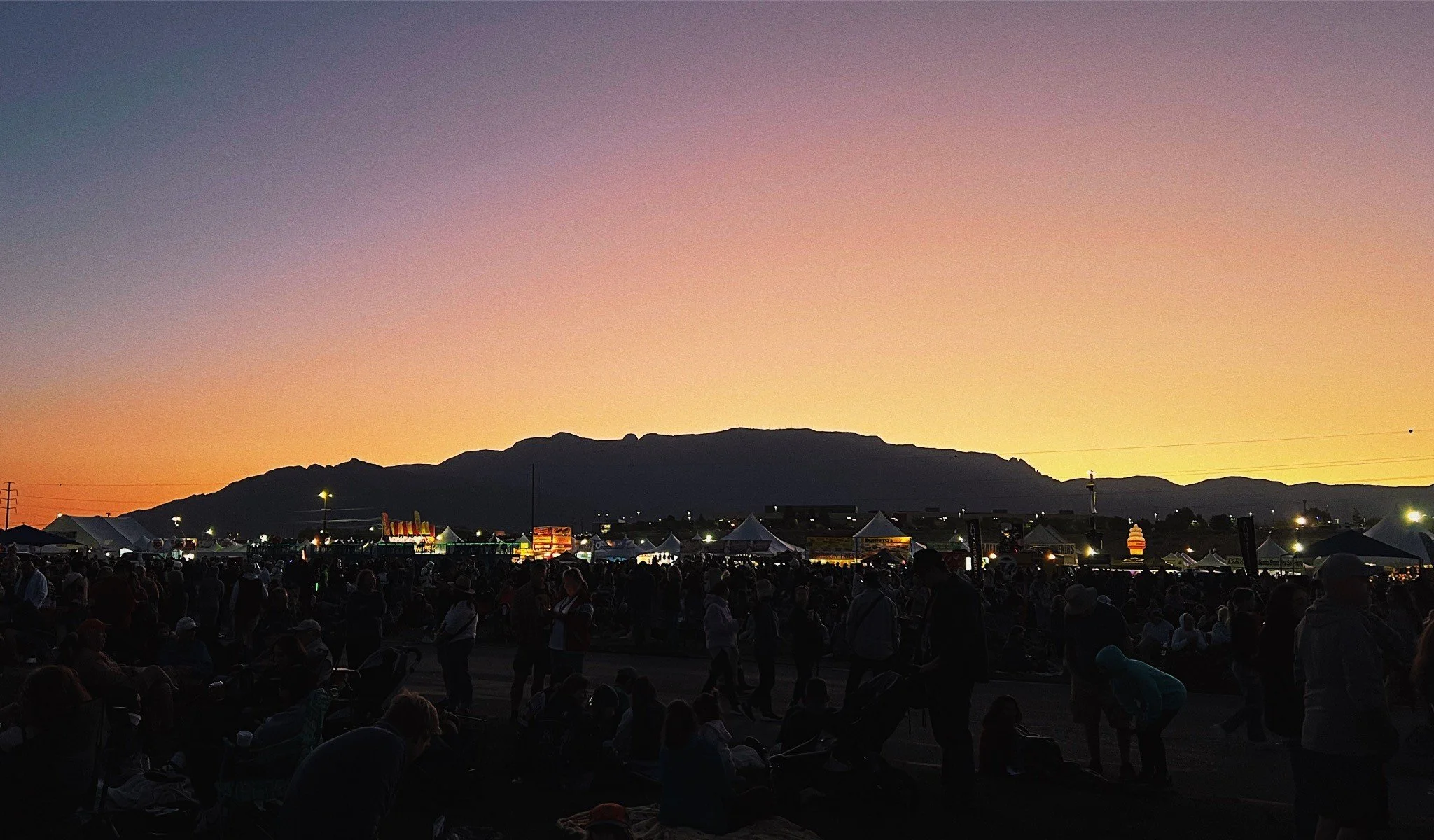 The sun begins to rise over the Sandia Mountains at the 2024 Albuquerque Balloon Fiesta.