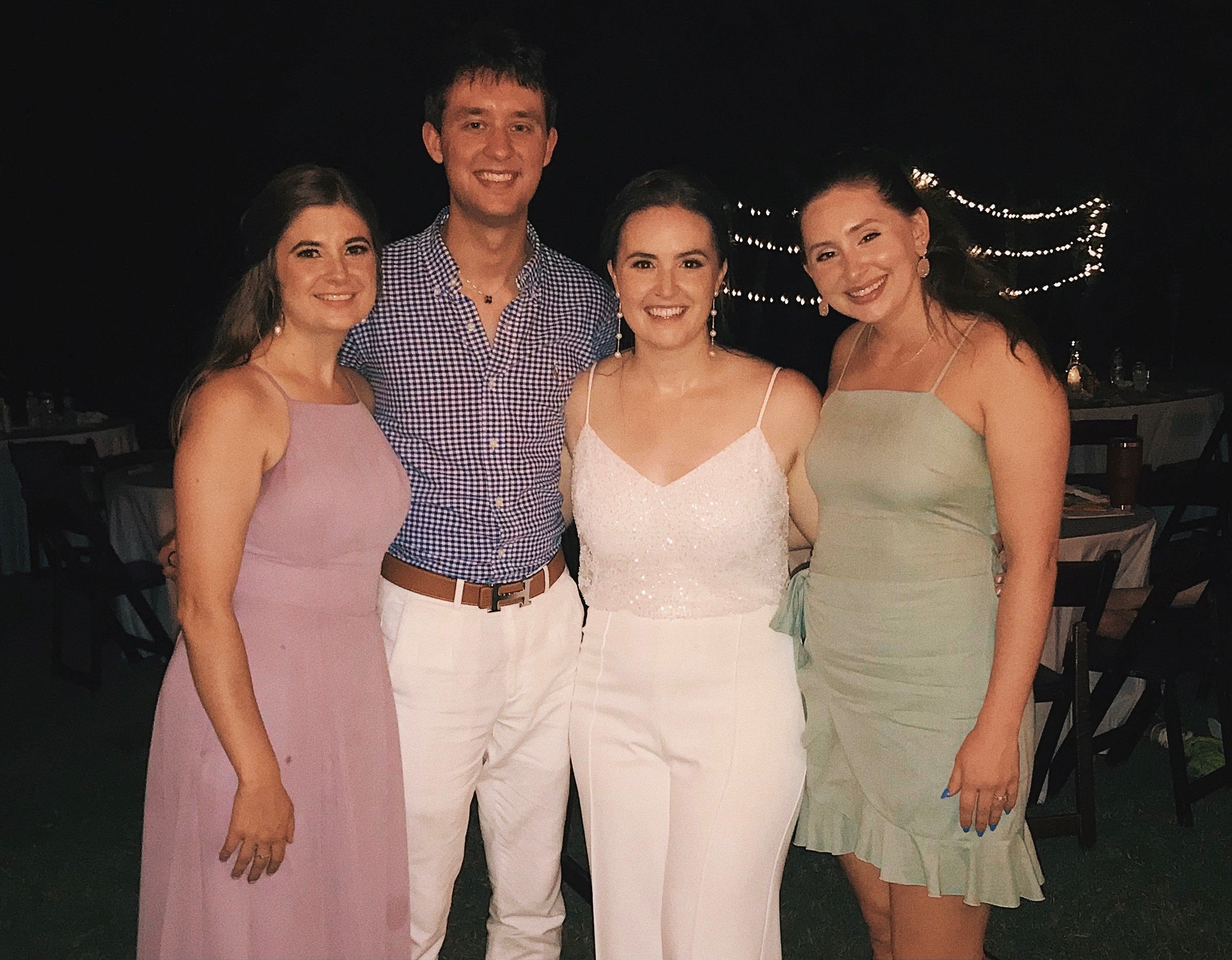 Four friends take a group picture at a wedding.