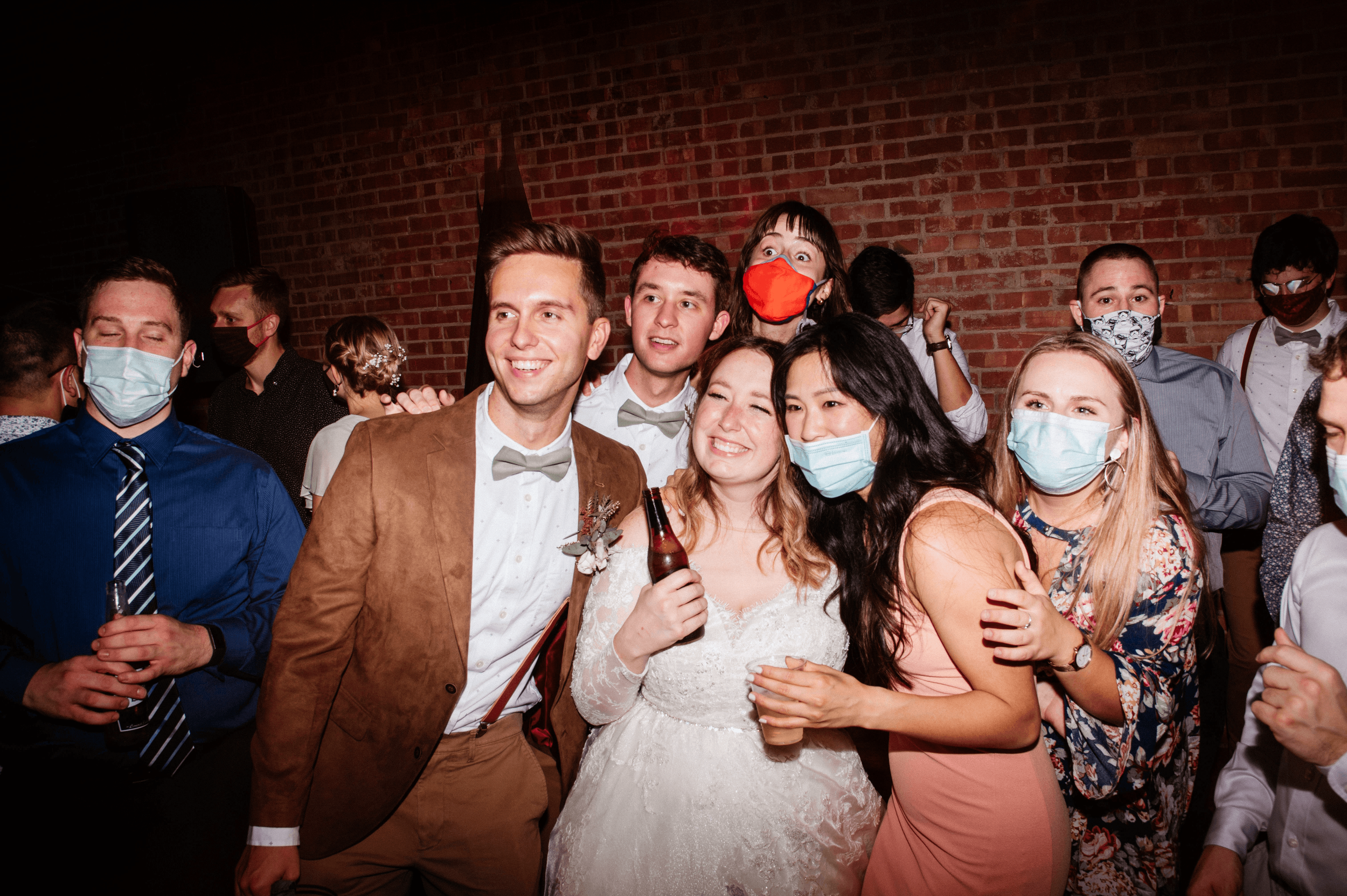 Friends take a group picture at a wedding.