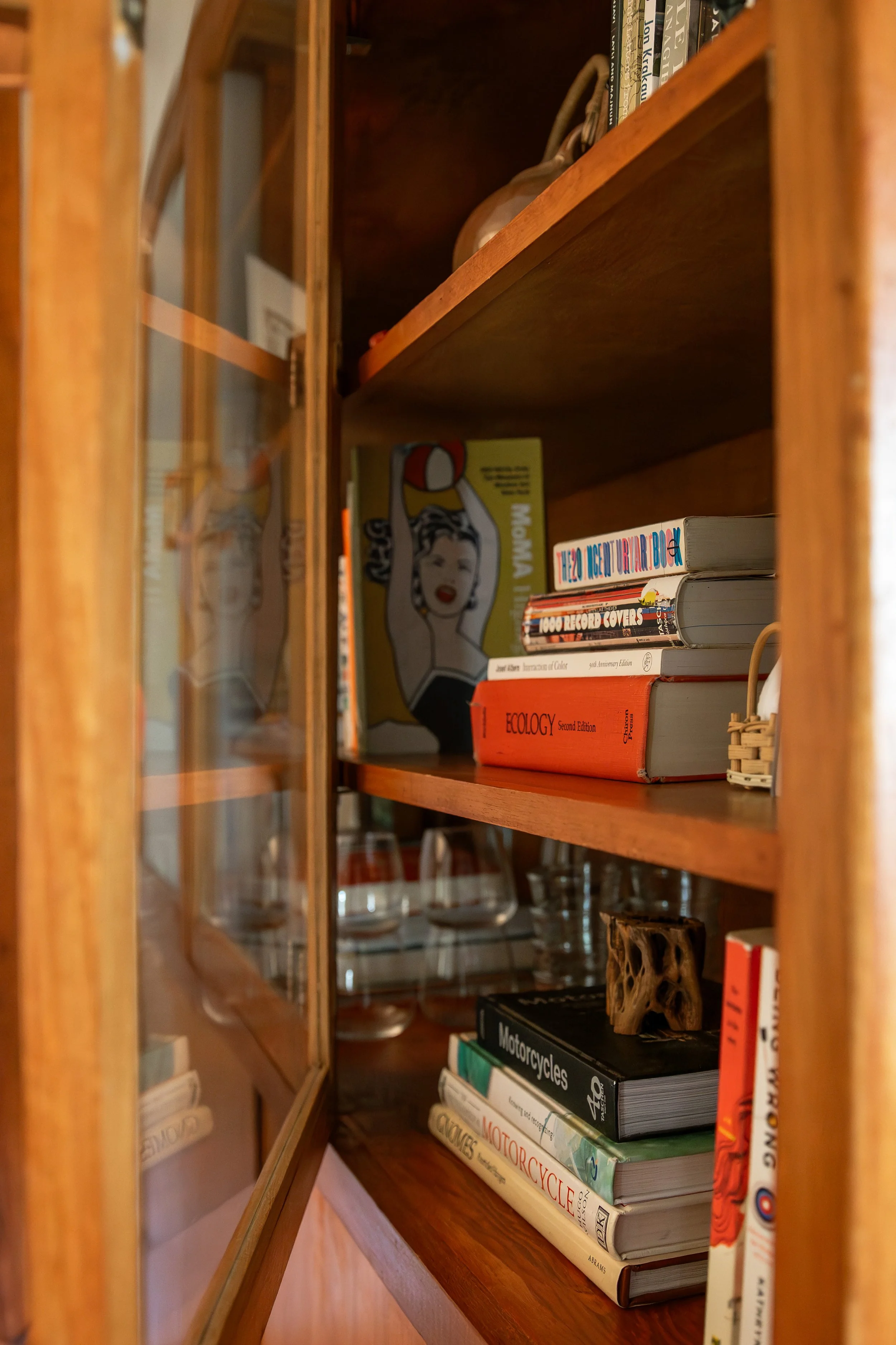 A wooden bookshelf with some books and decorative items. Bozeman interior design, interior renovation, and interior styling. 