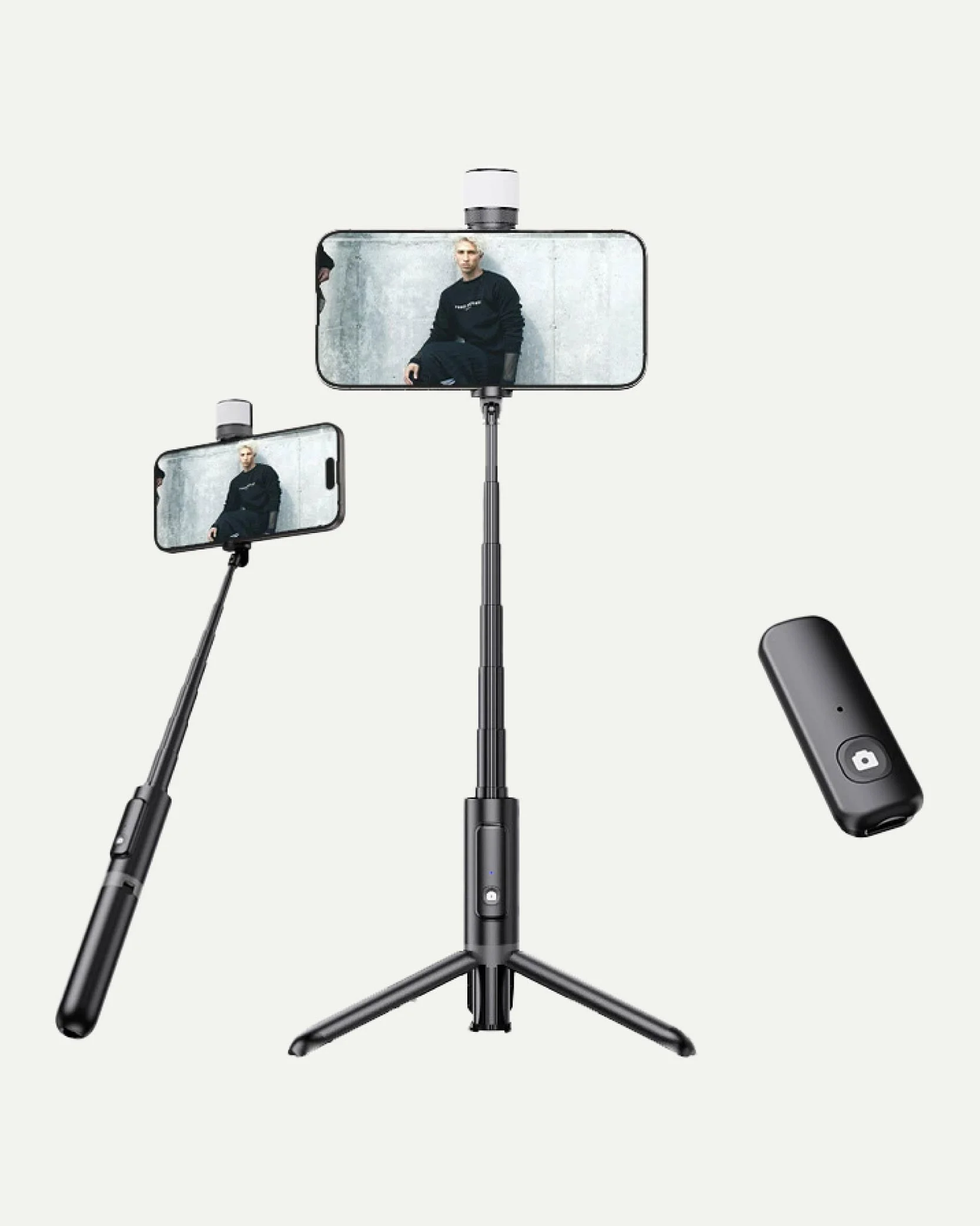 A smartphone tripod with a smartphone attached for taking selfies, a wireless remote control, and a selfie stick all set against a plain background.