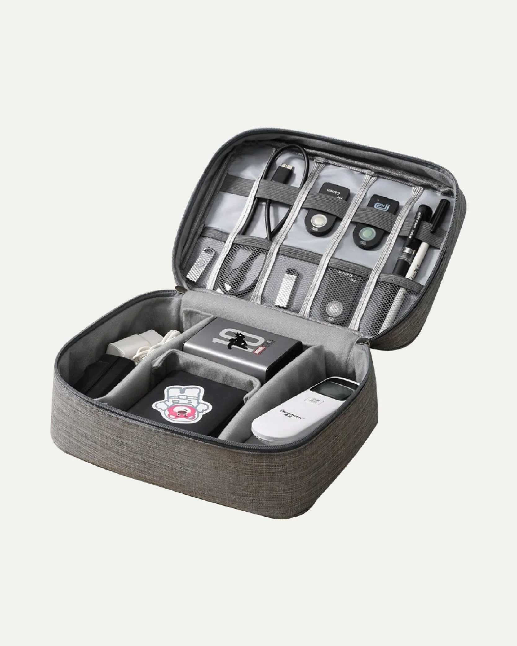 A gray travel organizer with various electronic accessories and devices inside, including chargers, cables, a remote, and small gadgets.