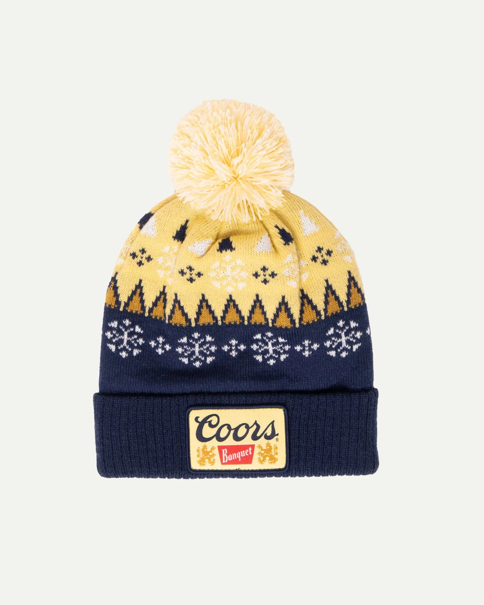 Yellow and navy blue knit winter hat with a pom-pom and pattern, featuring a Coors Banquet logo patch.
