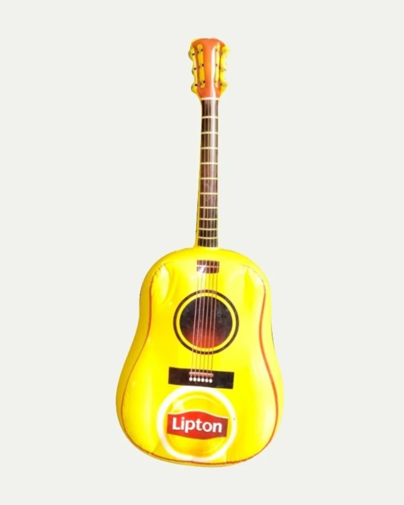 Yellow inflatable guitar with a Lipton logo on the body, designed to look like a real guitar.