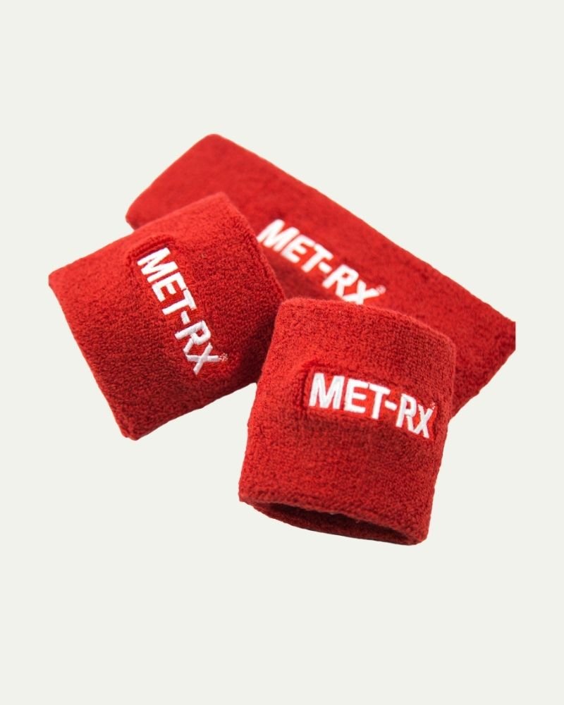 Three red fitness towels with white 'MET-RX' embroidered on them, arranged on a white background.