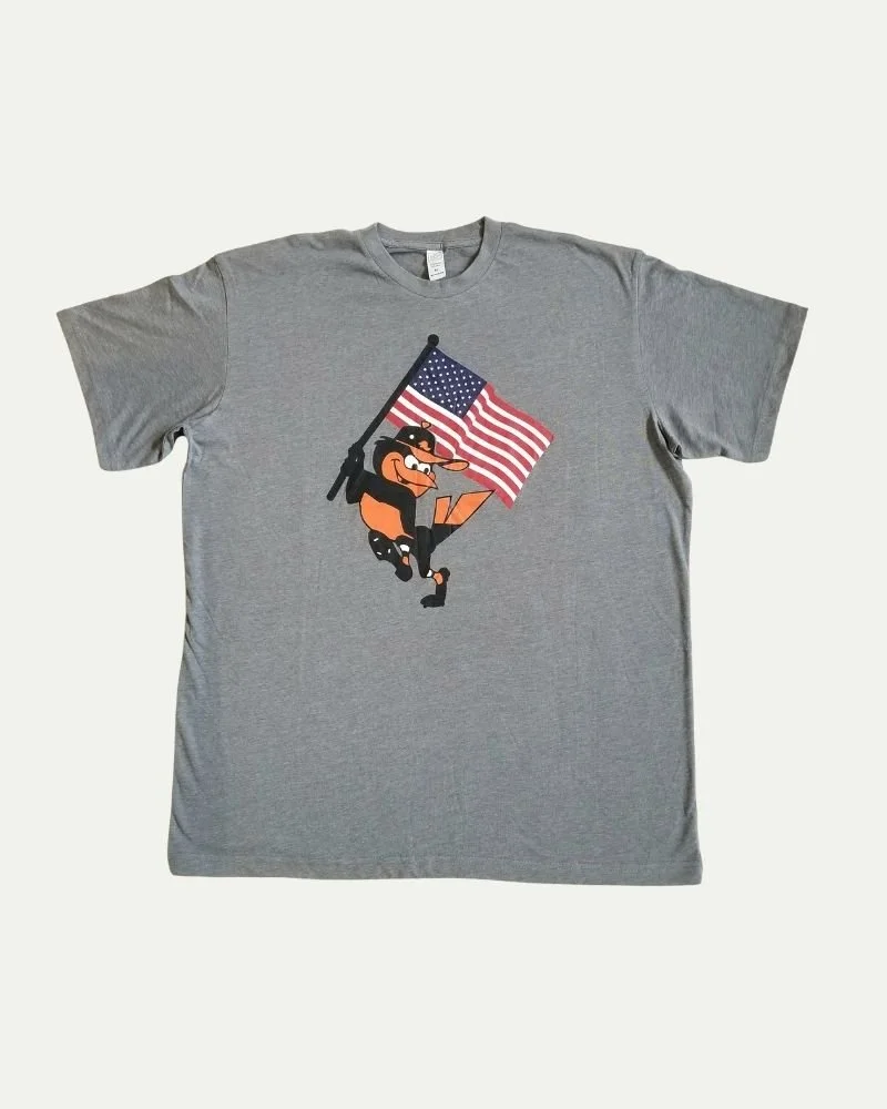 Gray T-shirt with cartoon character holding an American flag.