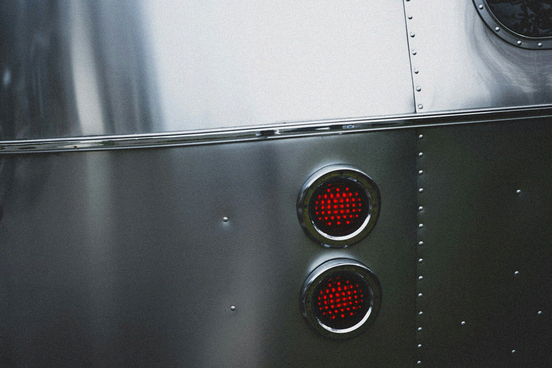 Close-up of a metallic surface with two glowing red circular vents.