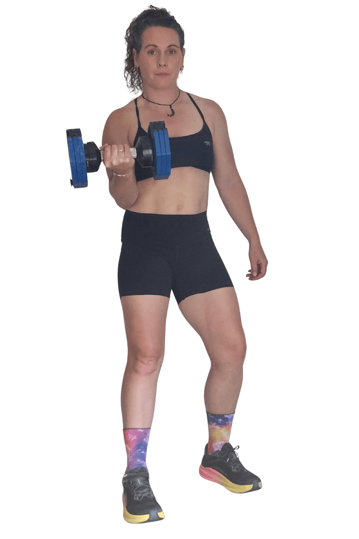 Woman lifting a dumbbell, wearing black sports bra, black shorts, colorful galaxy pattern socks, and sneakers, against a black background.