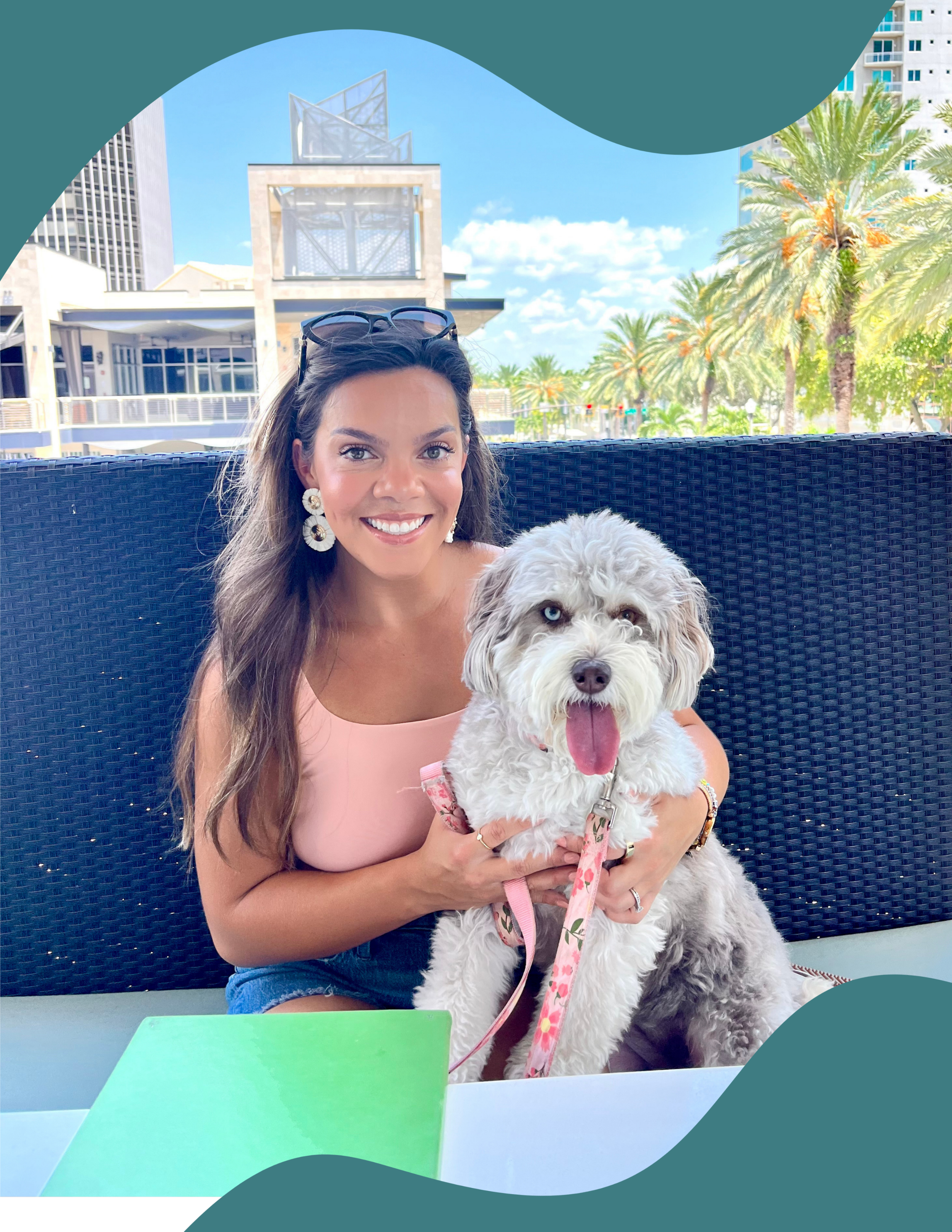 photo of brunette woman with white and grey dog sitting at a table