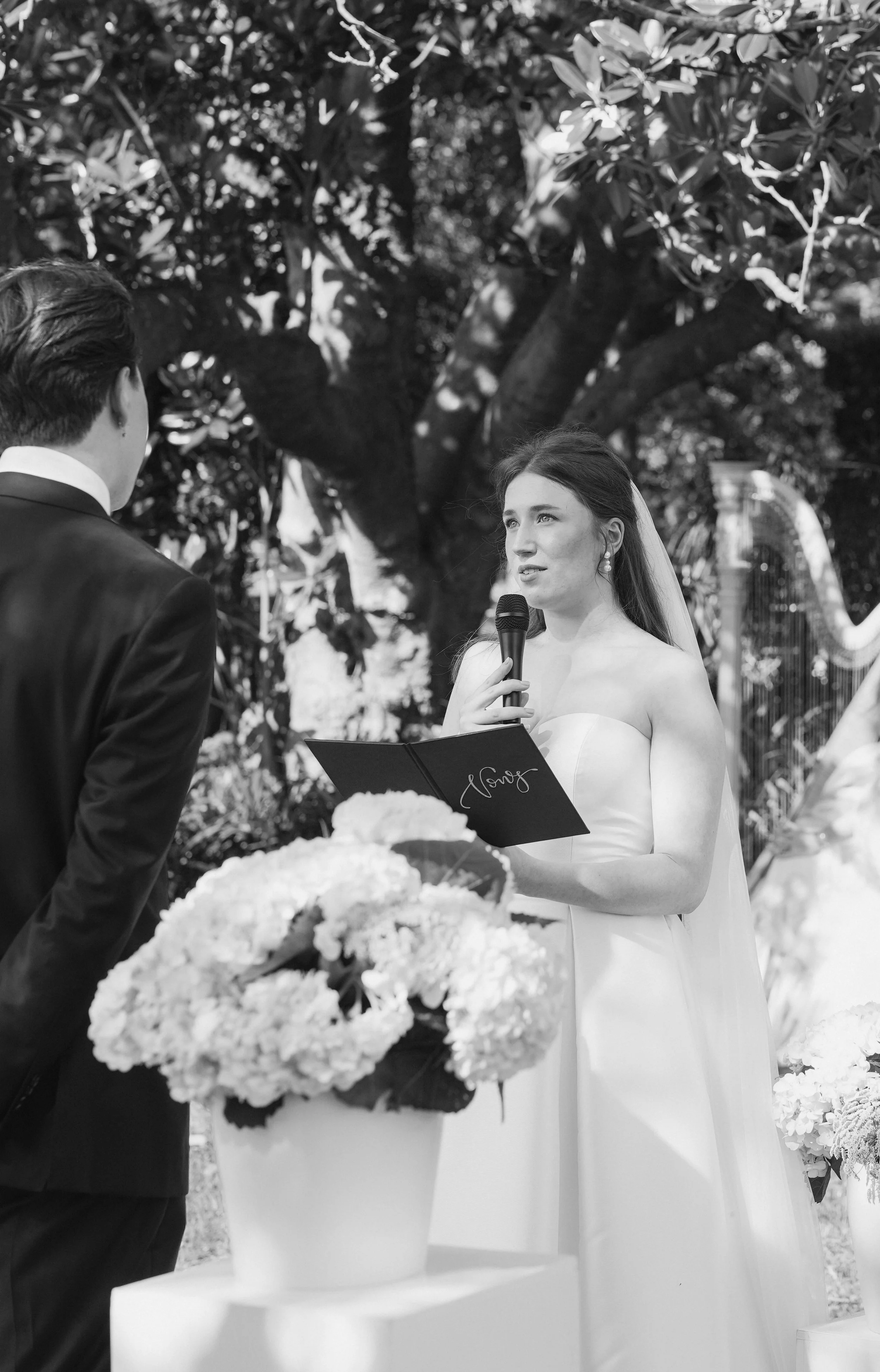 Bride reading her vows during an intimate wedding ceremony, photographed in black and white