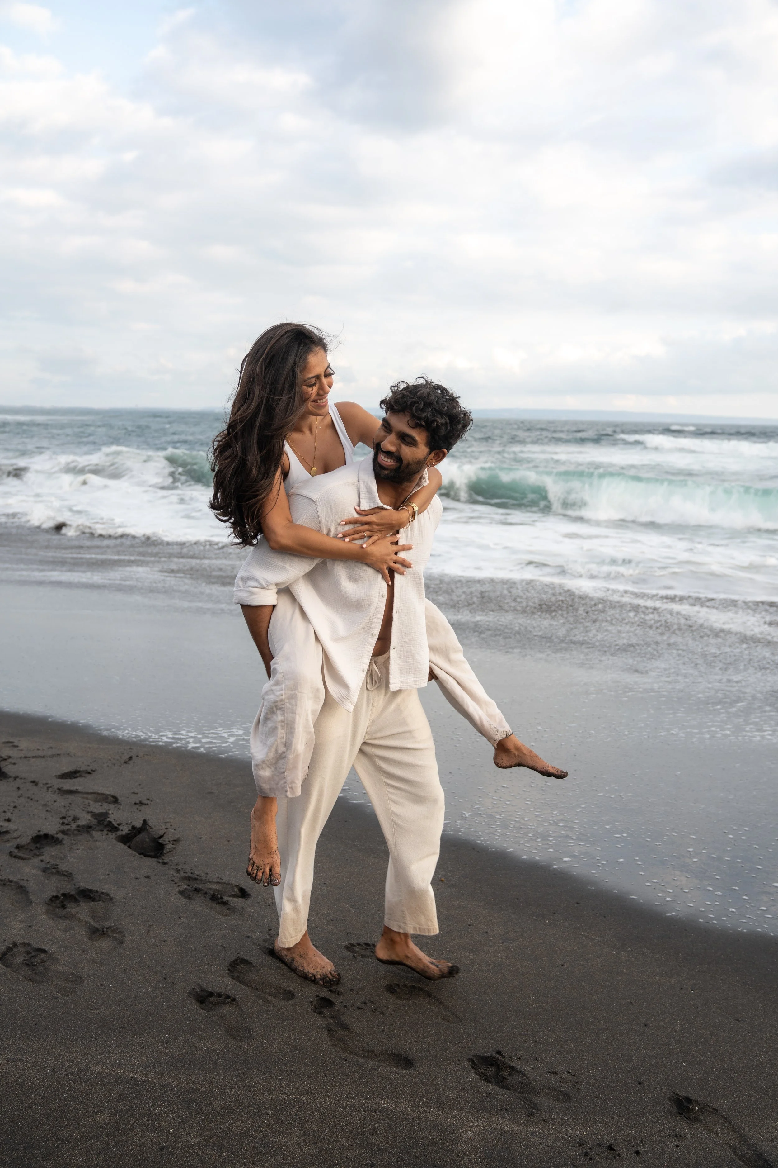 Couple laughing together on the beach during a relaxed and natural couples photography session