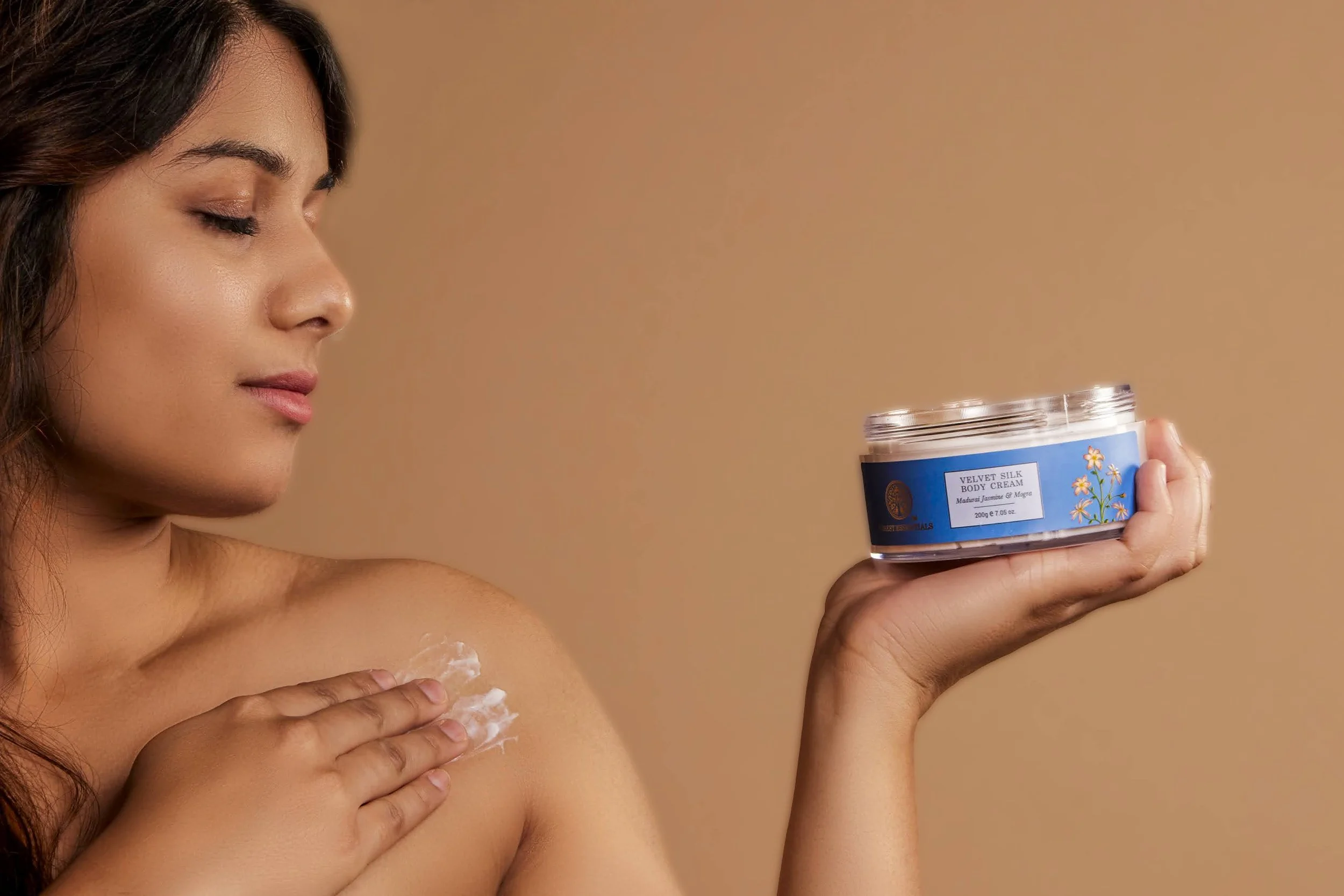 Velvet Silk Body Cream posed with a woman holding it. Product advertising photography