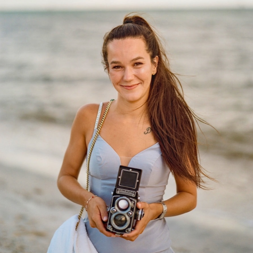 Woman holding a vintage camera on the beach