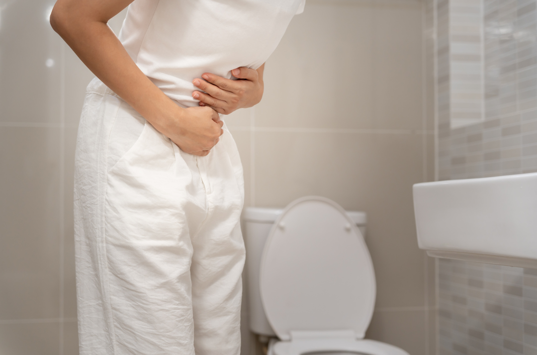 woman with constipation at toilet. stuck tool, straining to poop, painful poops, pooping problems. IBS support. Can pelvic floor therapy help constipation?