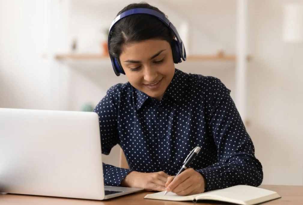 woman on lap top taking notes to understand her pelvic health, vulva, and pelvic floor muscles