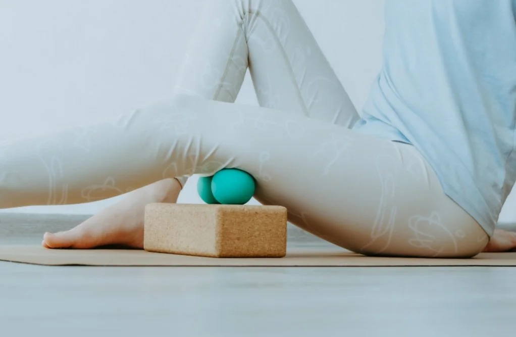 person doing trigger point release with trigger point ball and block to release tension in muscles