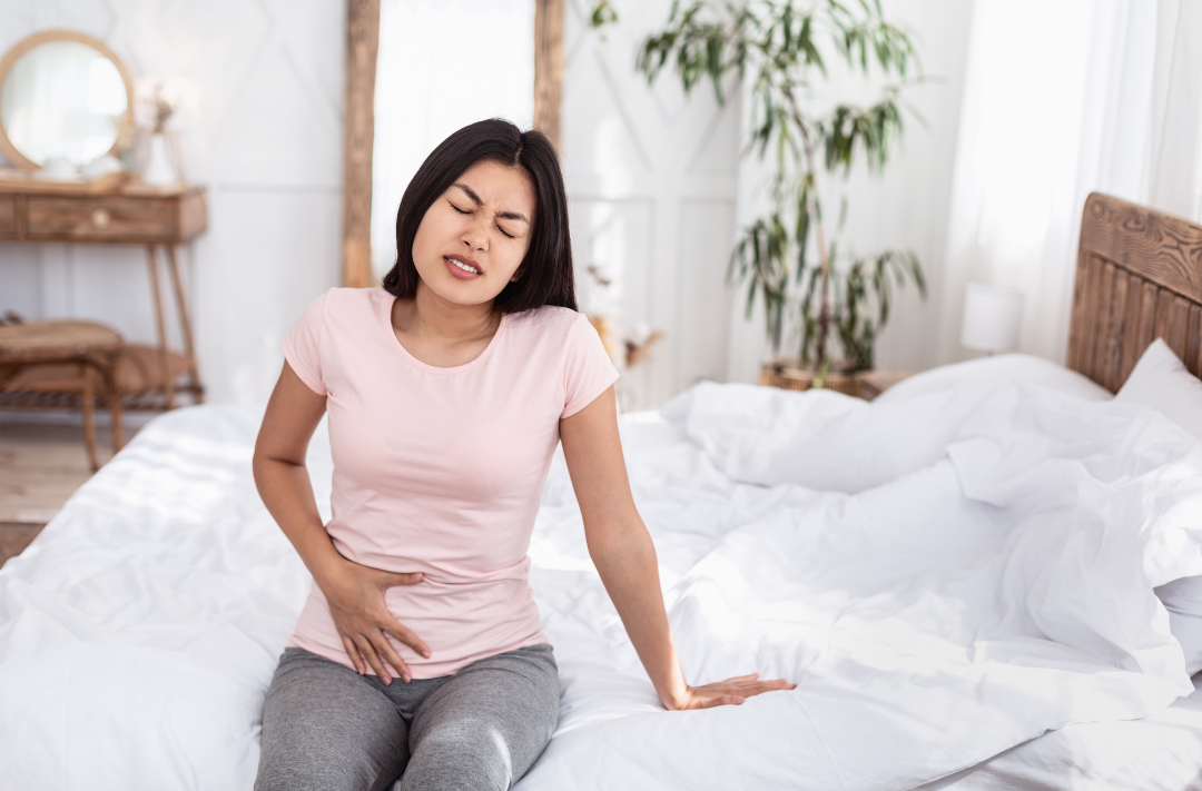 woman holding abdominals in pelvic pain, pain from endometriosis, pain from tight pelvic floor muscles, hypertonic pelvic floor muscles, chronic pelvic pain, pelvic floor pain, painful vagina, vuvlodynia, vaginismus, low back pain, abdominal pain.