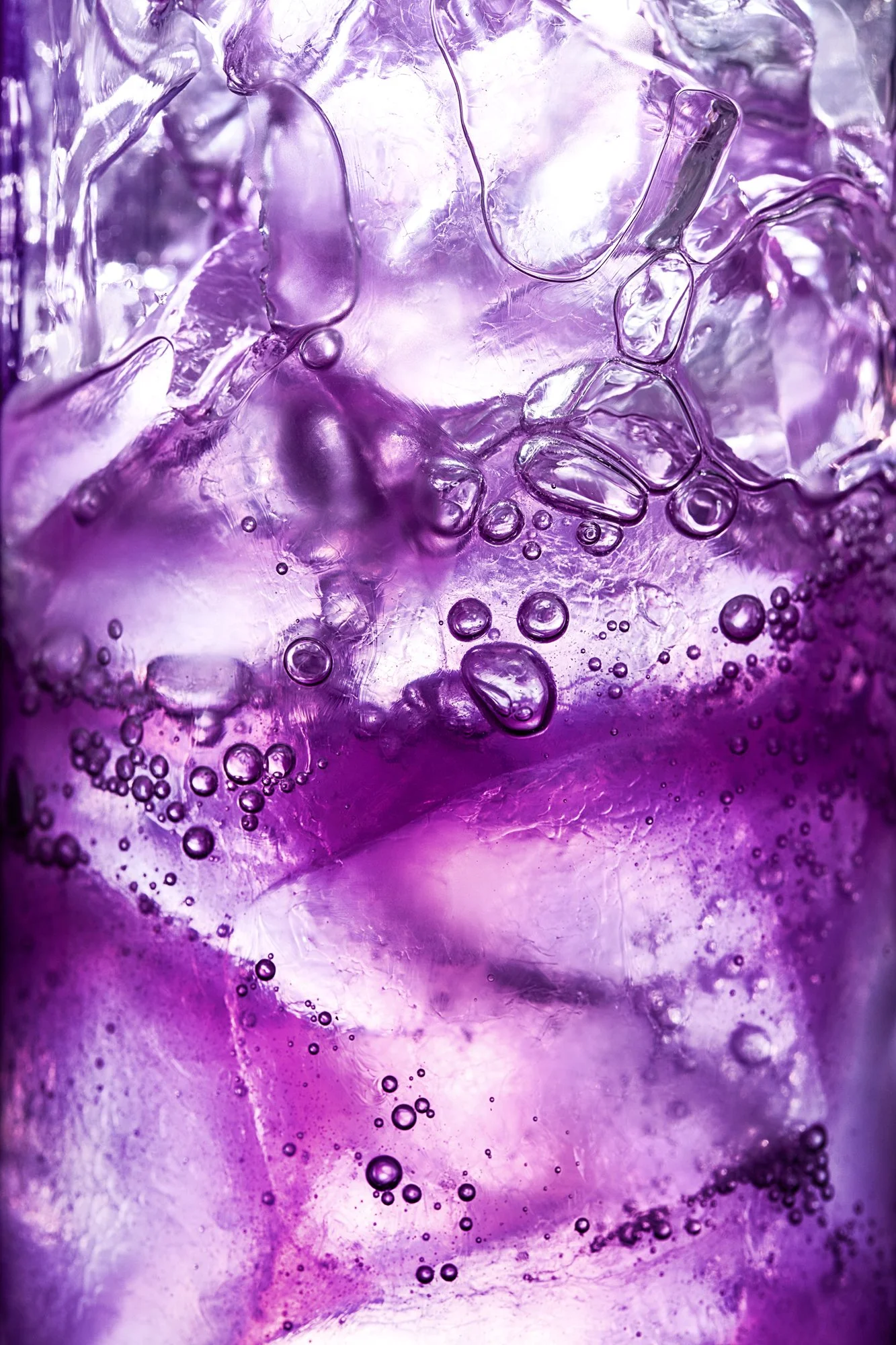 Close-up of purple and clear ice with bubbles trapped inside.