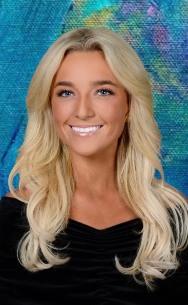 A smiling woman with long blonde wavy hair, wearing a black top, against a colorful, textured background.