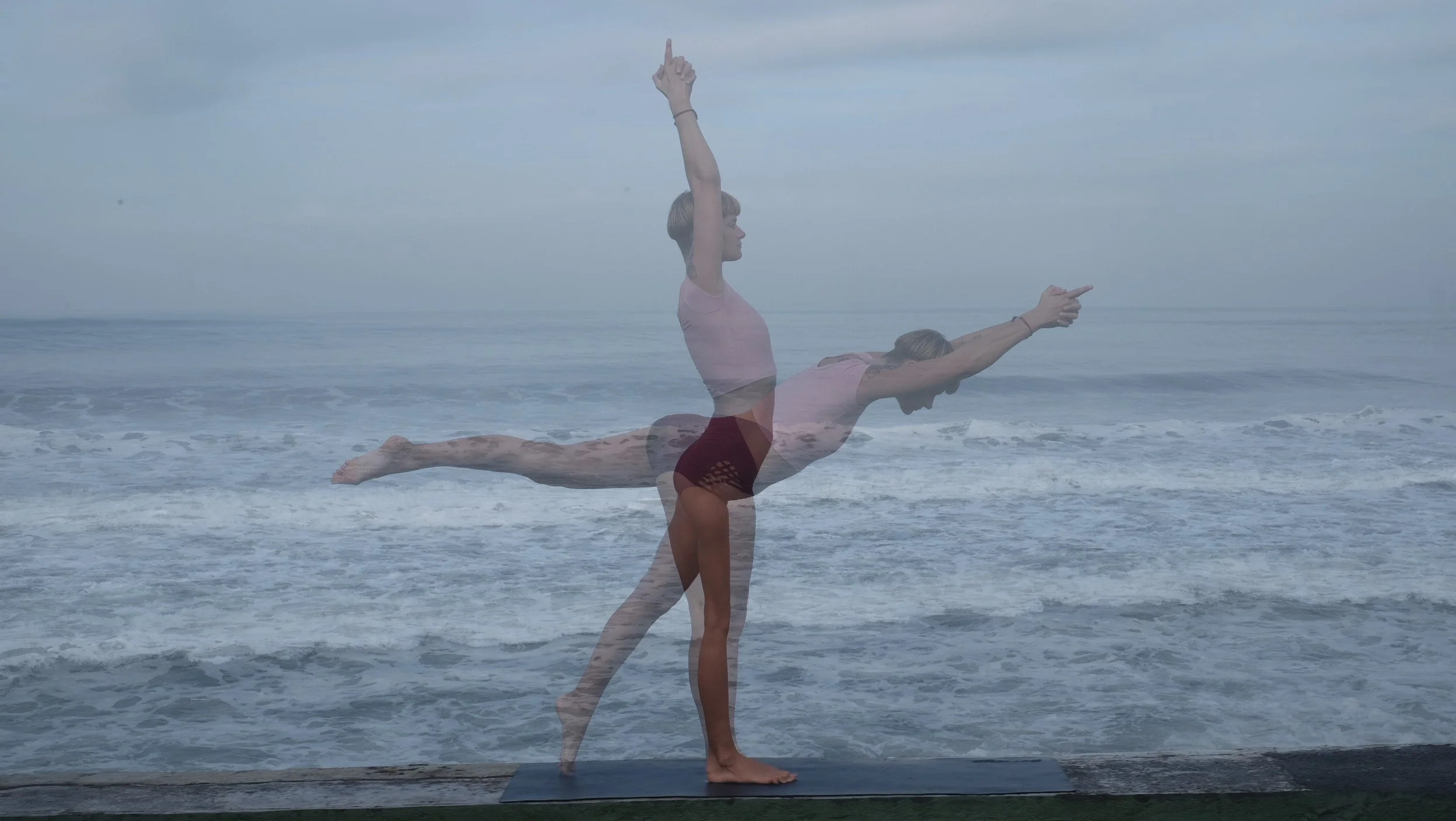A woman practicing yoga on a beach, demonstrating a warrior pose with a transition to airplane pose, the ocean and cloudy sky in the background.