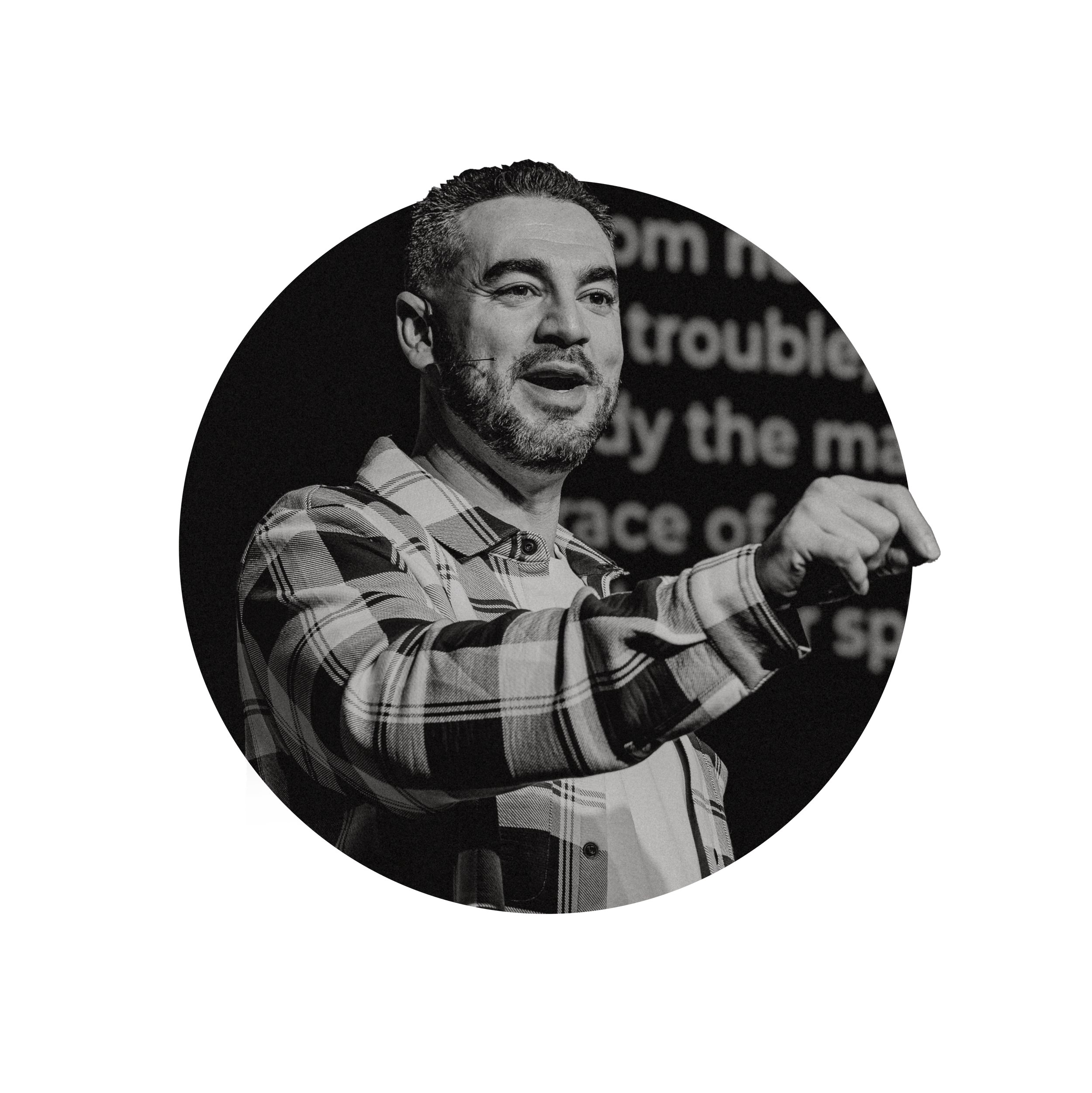 Heiden Ratner, Pastor of Walk Church in Las Vegas, Nevada, wearing a checkered shirt, speaking on stage with a blurred screen in the background.