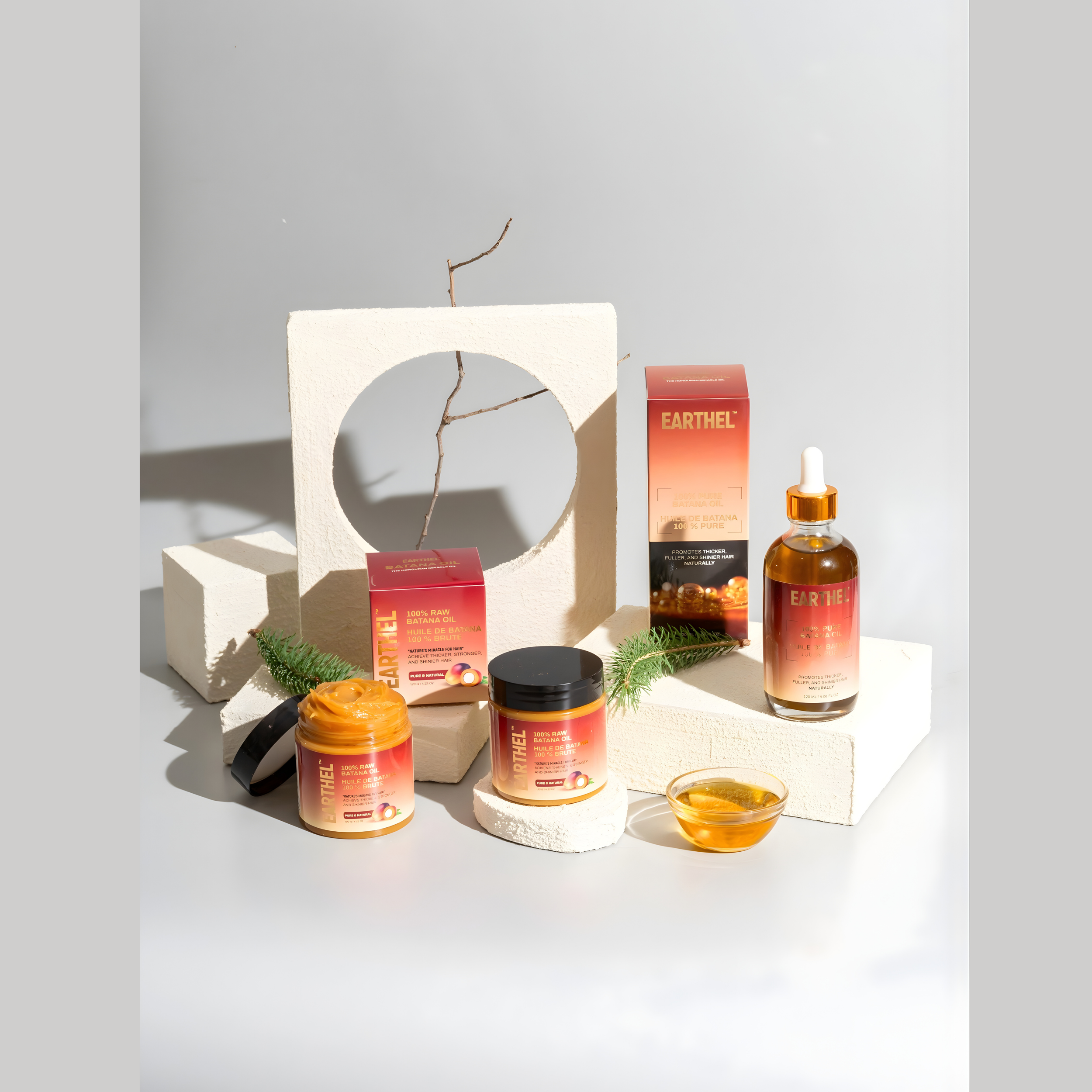 Display of skincare products including a bottle with a dropper, a jar, and boxes, arranged on white geometric blocks with sprigs of greenery and a small glass dish, with natural lighting and shadows.