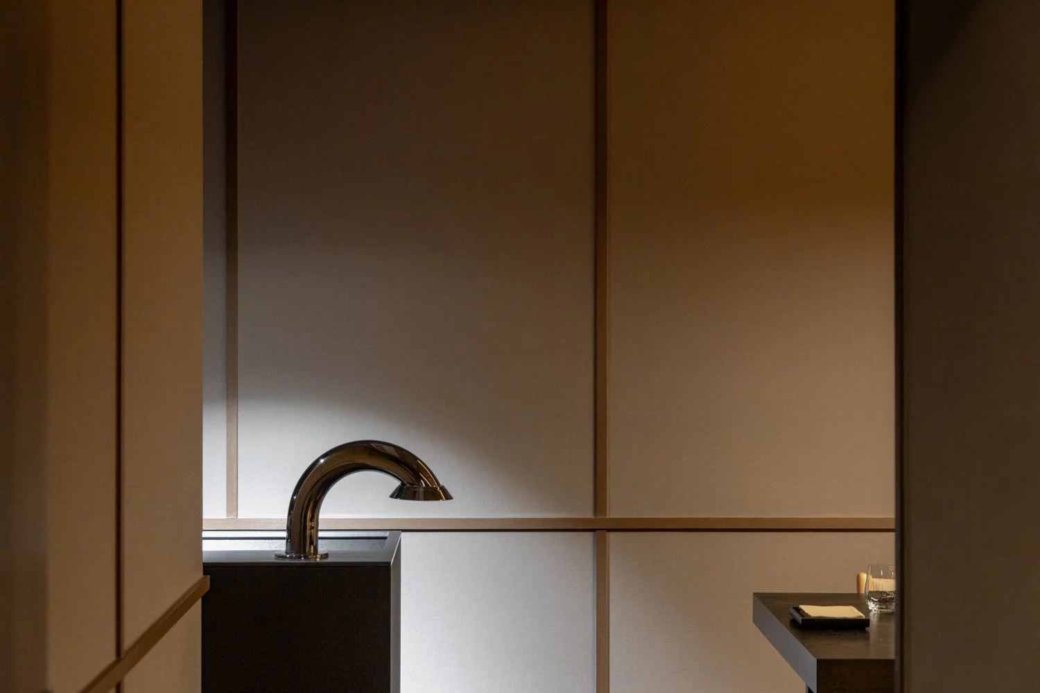 Empty room with a modern faucet, small table with a glass and notepad.