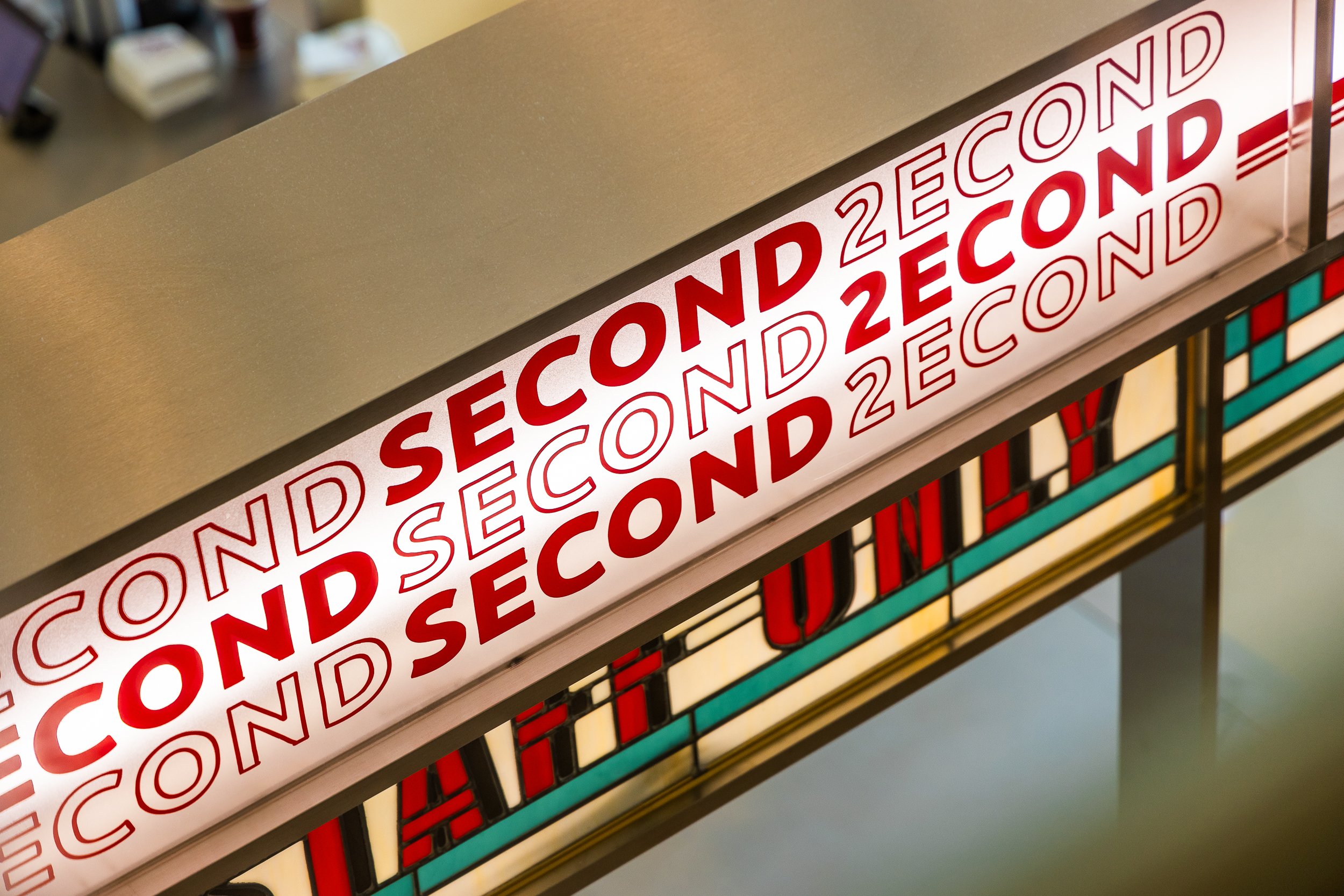 Sign displaying 'SECOND' repeated multiple times in red text on a light background