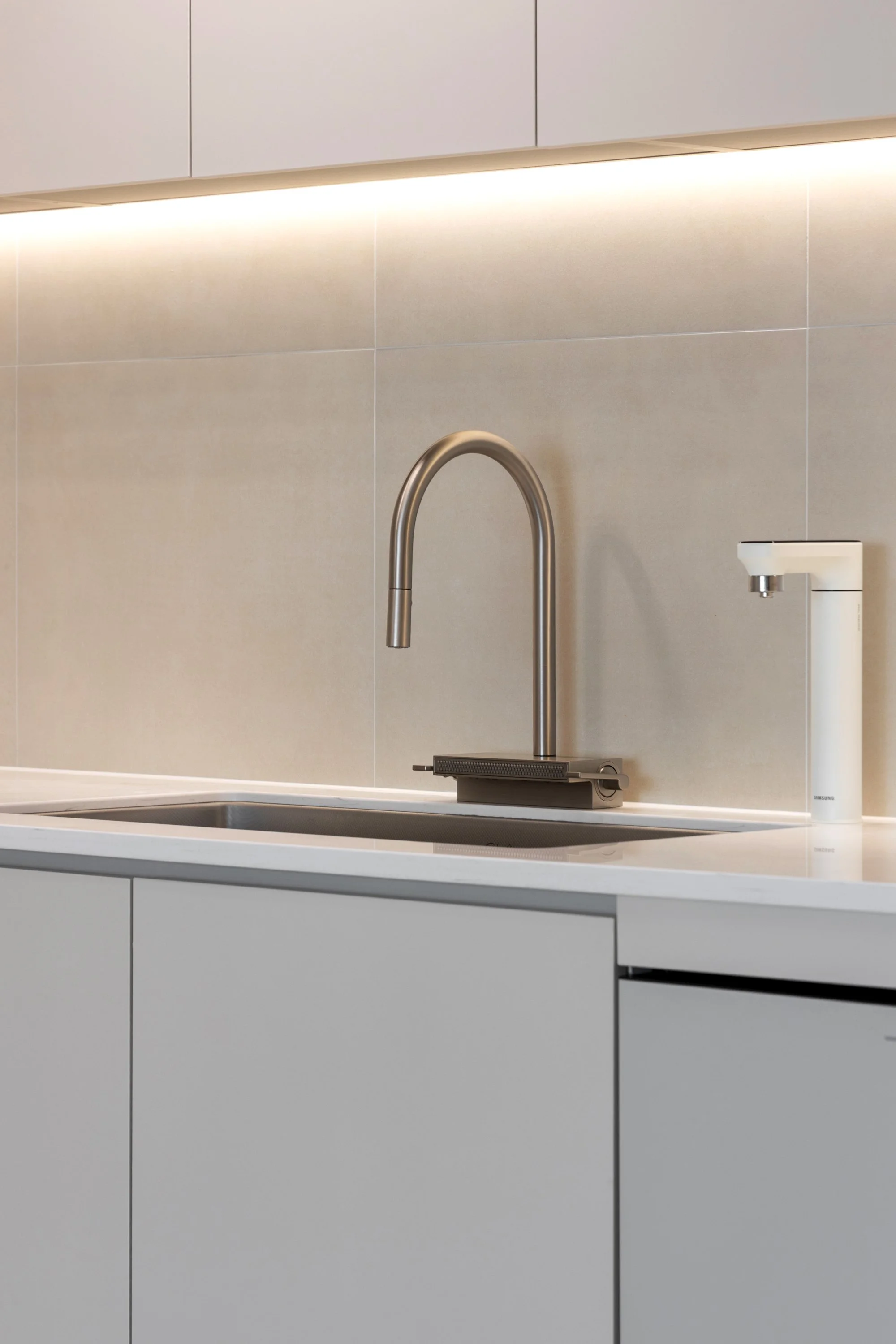 Modern kitchen with a stainless steel faucet, white Designer faucet, and beige tiled backsplash.