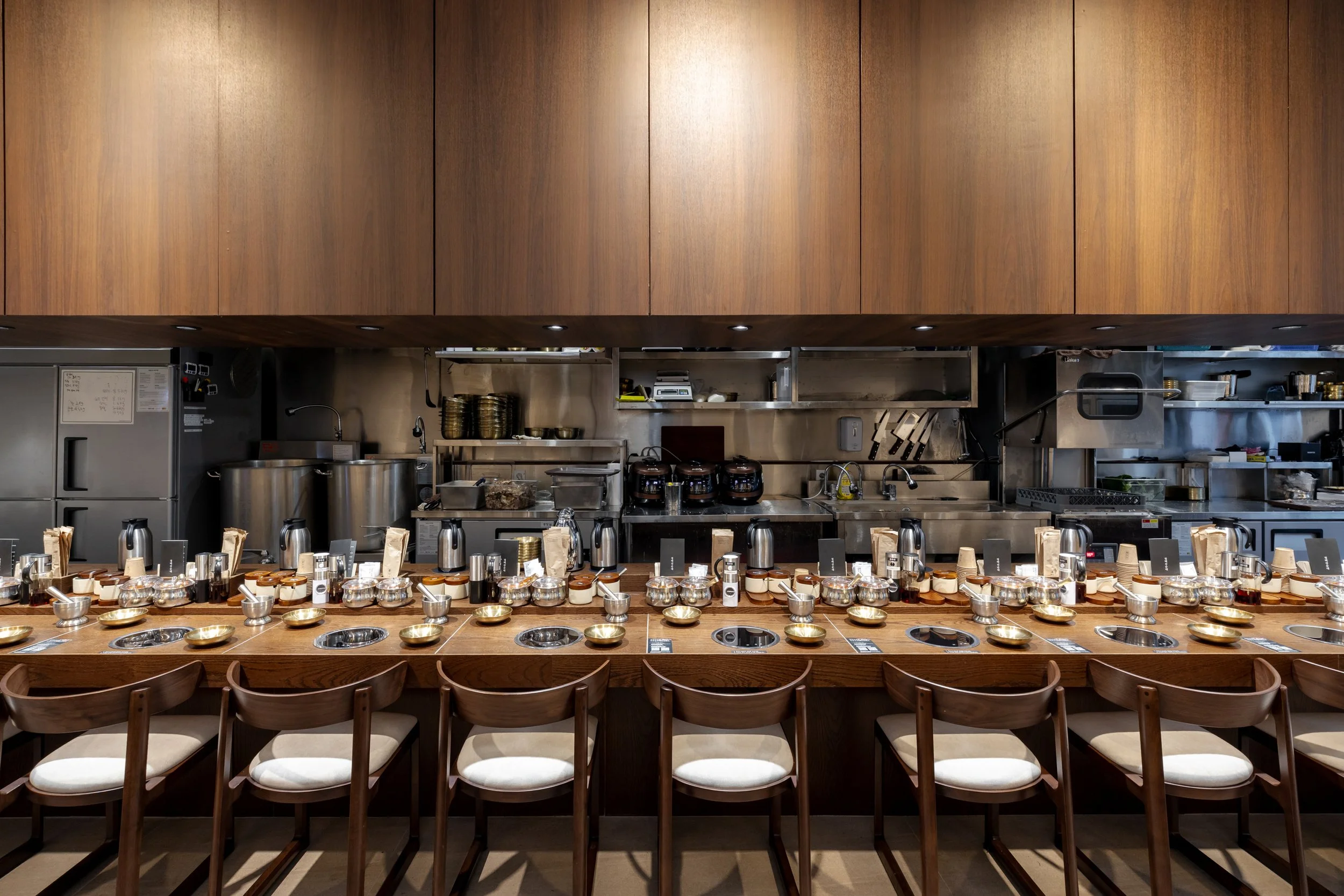 Empty tea tasting bar with small bowls, teapots, cups, and tasting notes, in a restaurant kitchen.