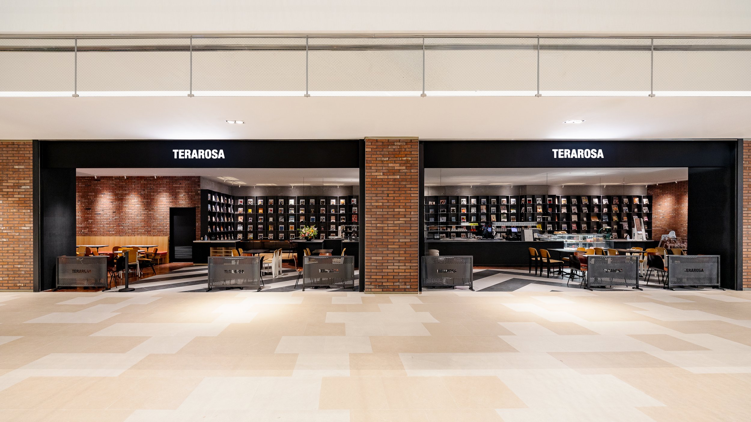 Indoor bookstore named TERAROSA with black signage, brick walls, and shelves filled with books, viewed from a distance across a tiled floor.