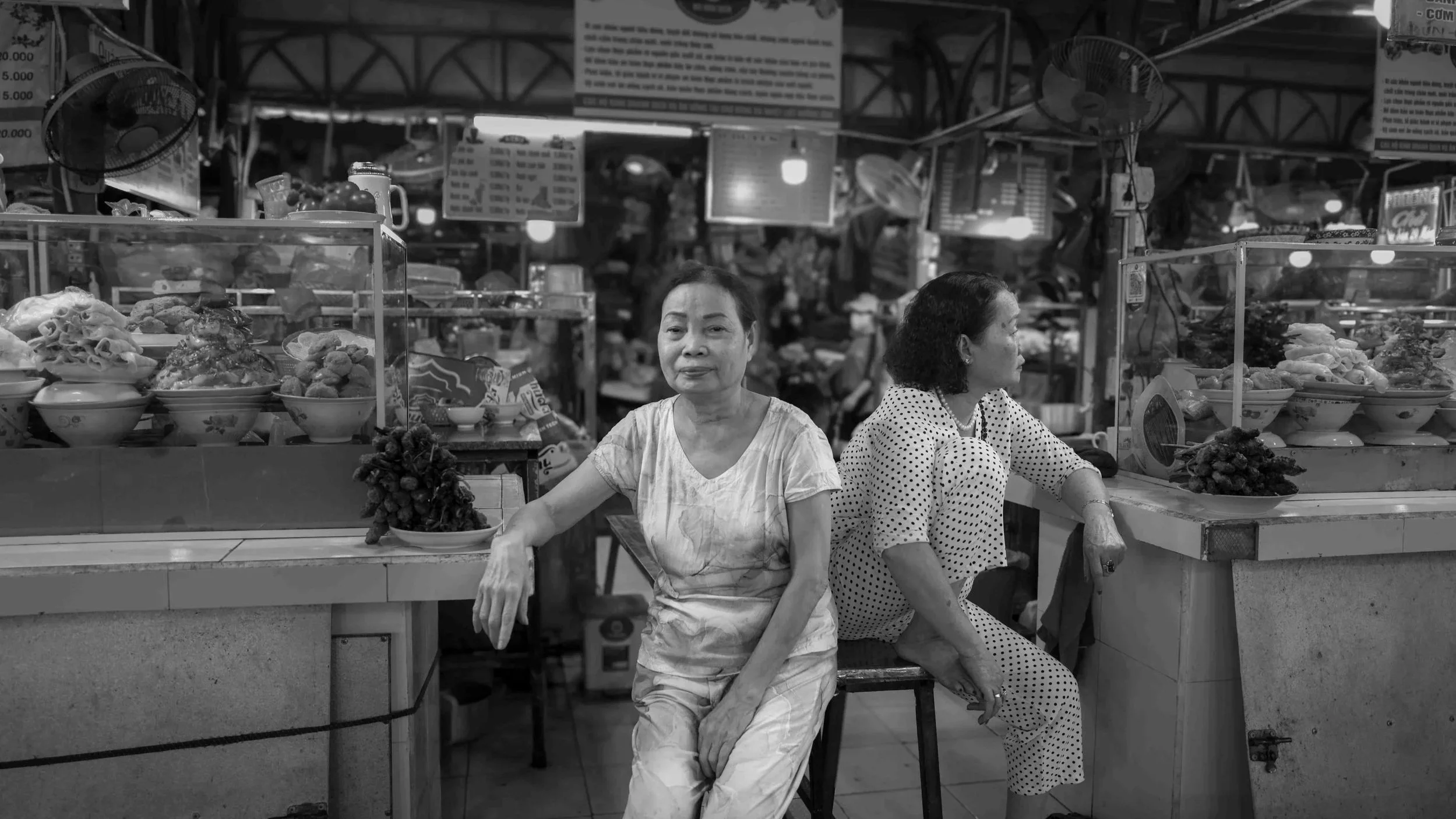 The busy food market in Hue also had some quiet times where merchants appeared bored.  I photographed these sisters waiting patiently by their food stands.