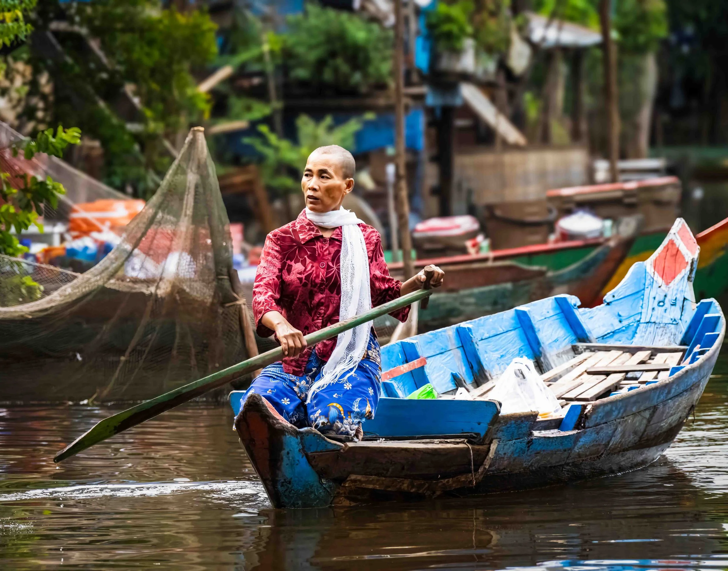 This woman is bringing supplies to the community Pagoda for a water festival. Her shaved head likely signifies that she is a widow in mourning.