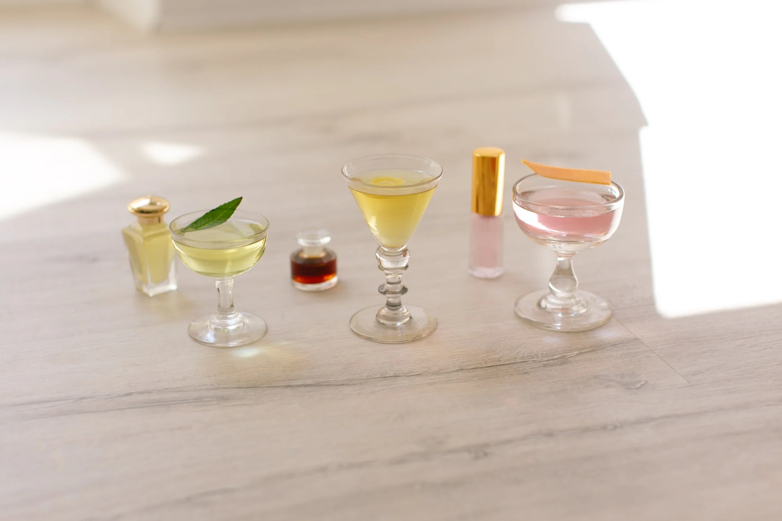 Selection of refined cocktails presented in elegant glassware, showcasing contemporary mixology with botanical ingredients and minimalist styling.