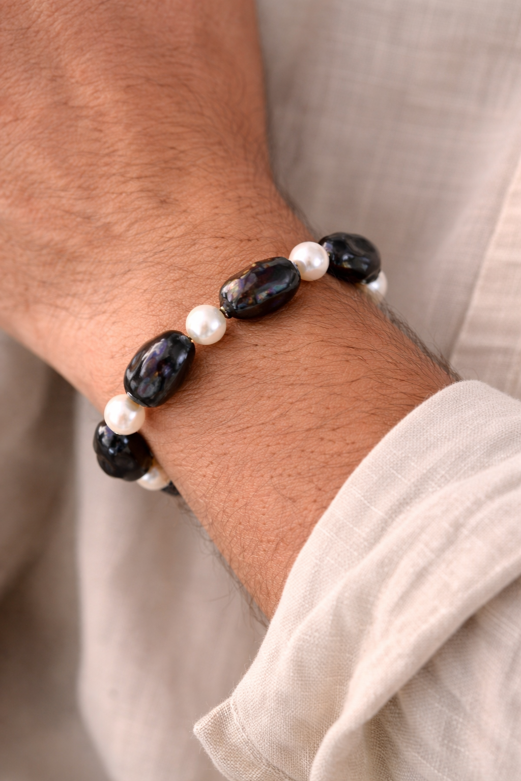 Elegant pearl bracelet on tanned wrist.png