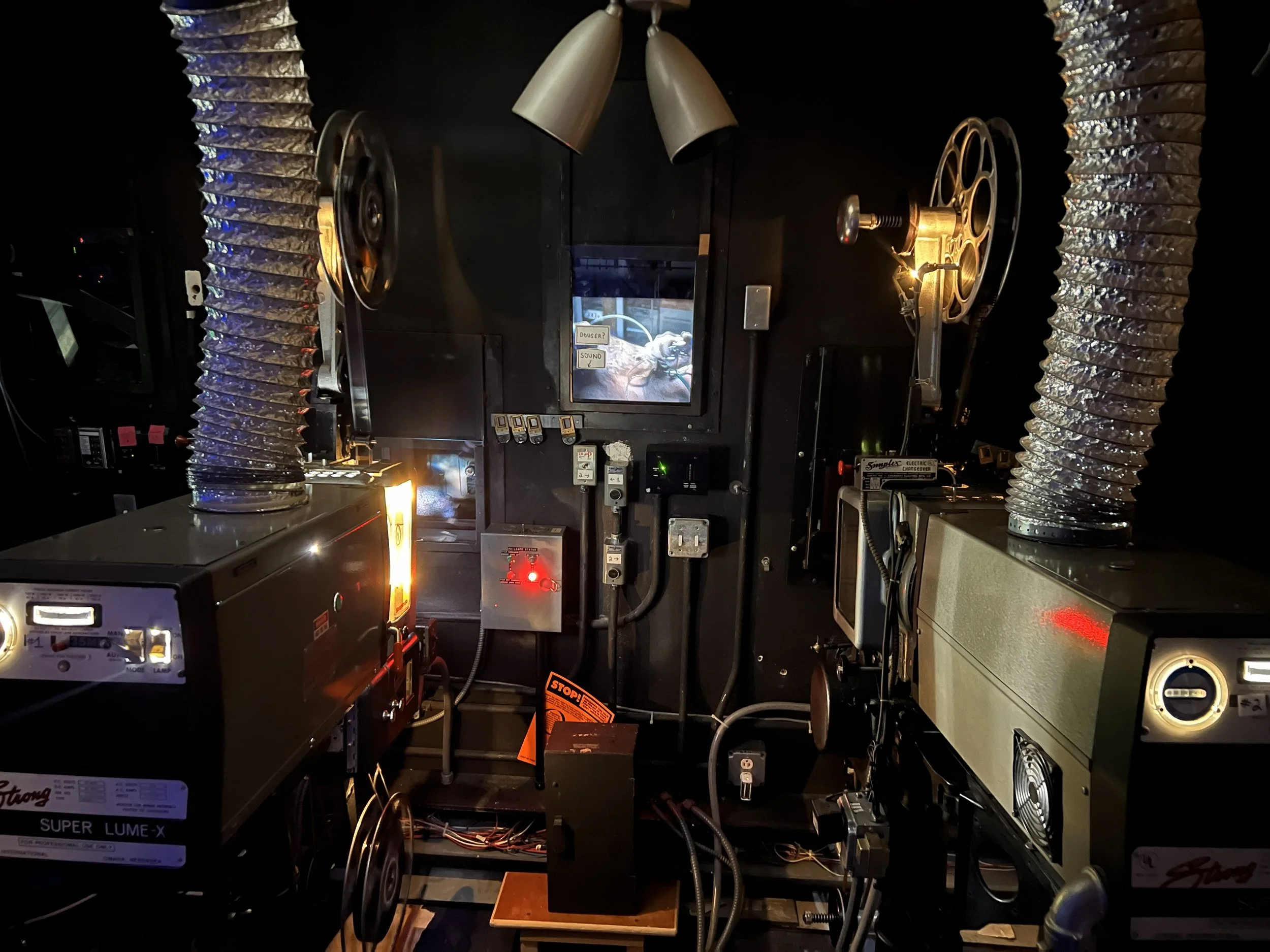 Interior view of a vintage experimental laboratory with old scientific equipment, large metallic ducts, and monitors.