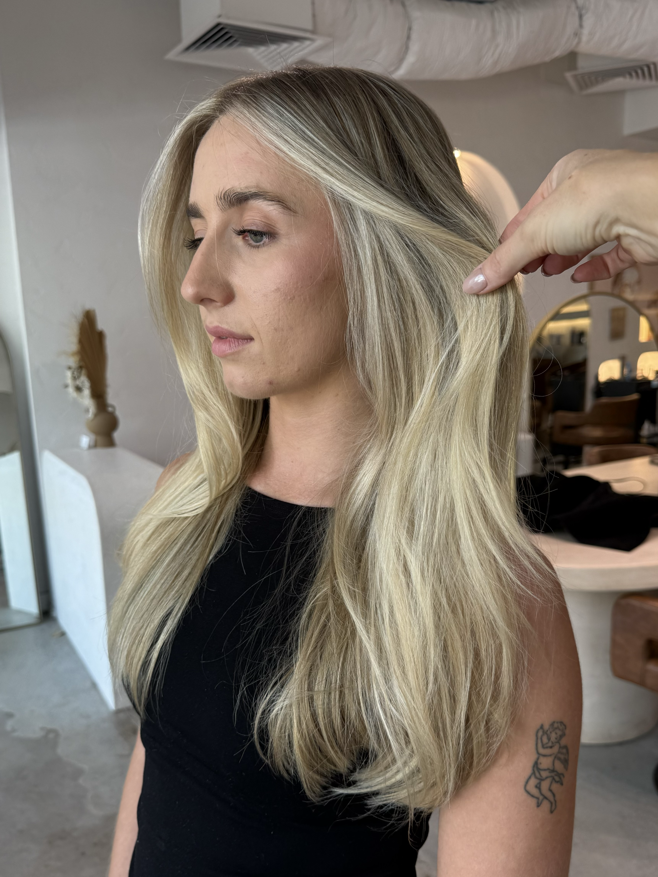 Close-up of glossy blonde balayage with smooth texture and soft beach waves.