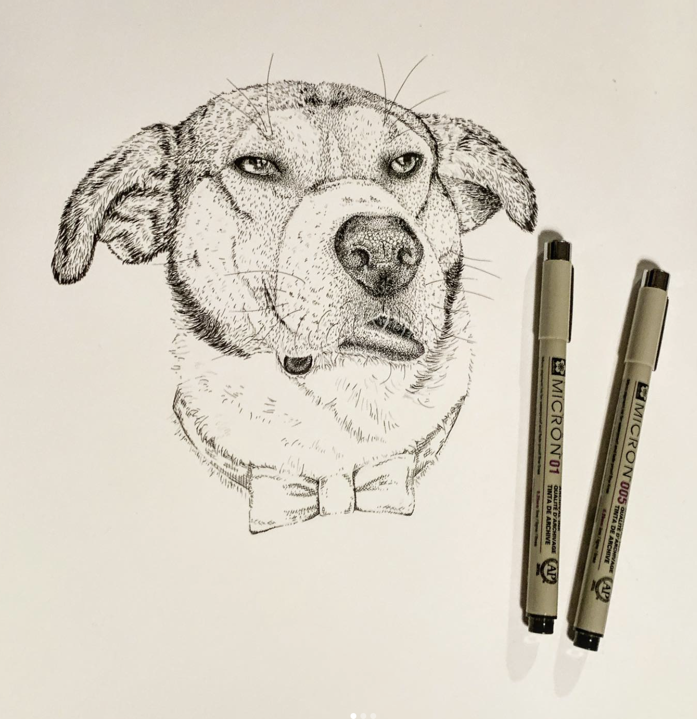 A detailed black and white drawing of a dog wearing a bow tie, created with fine lines and shading. Two gray markers are placed beside the drawing.