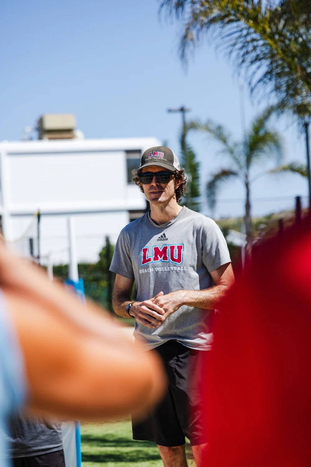 Coach John Mayer talking with athletes at practice