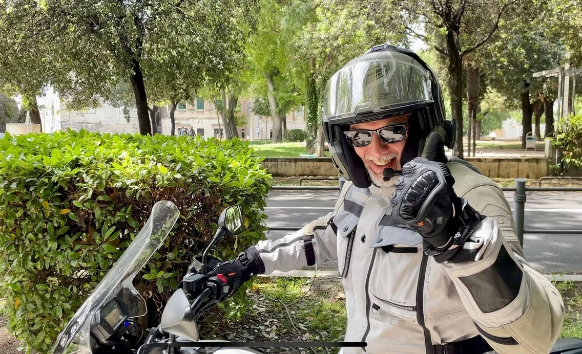 Motorcycle guide wearing protective gear, riding through the city of Split, near the Diocletian Palace - UNESCO Heritage site.