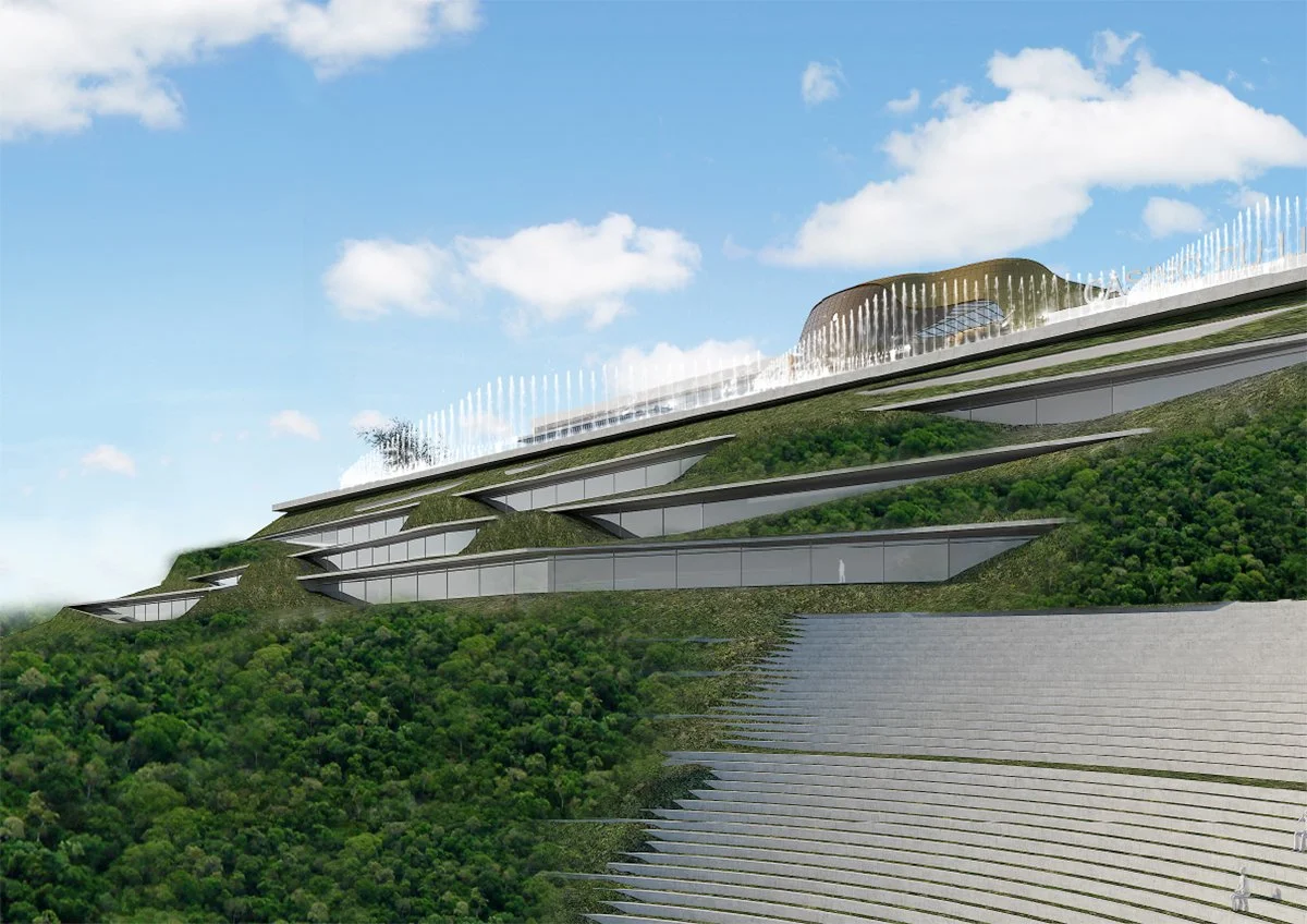 A futuristic building with multiple levels and green roofs, situated on a hillside, with a fountain on top and a bright blue sky with clouds in the background.