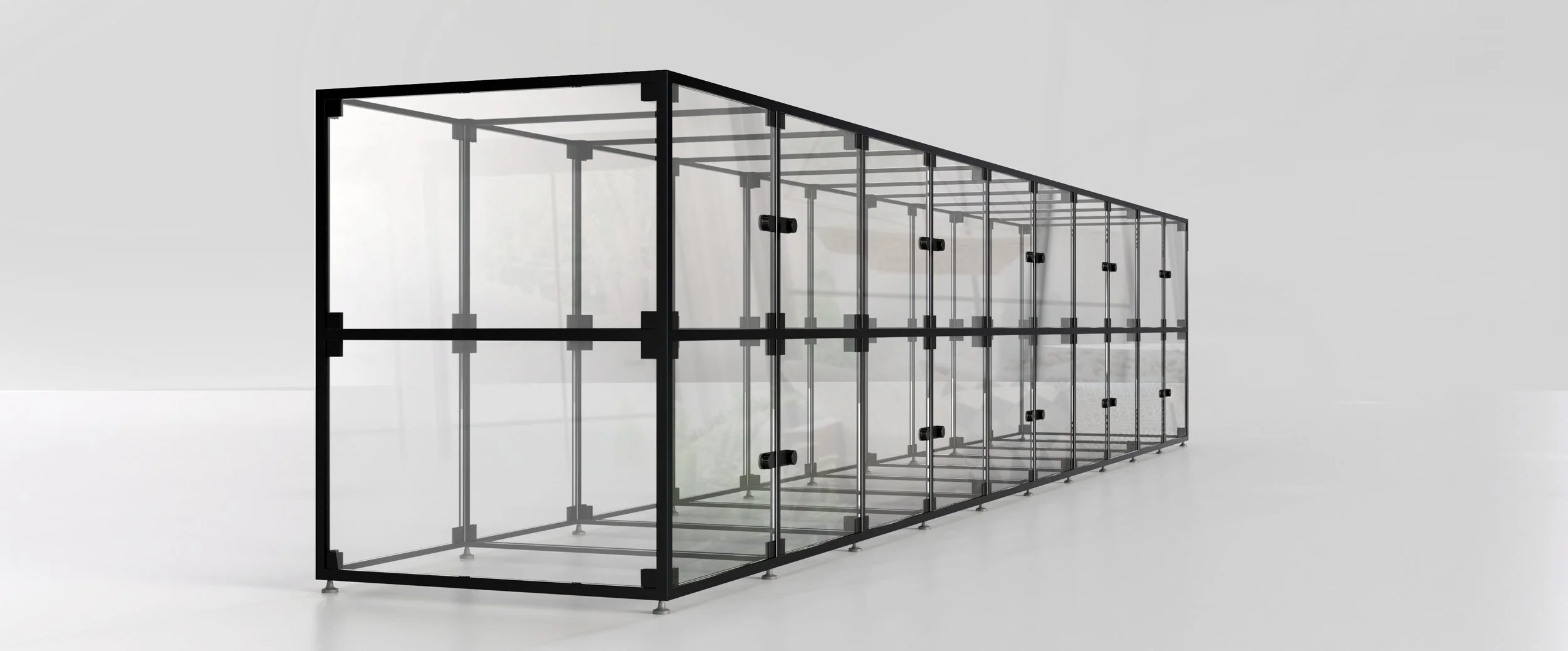A modern glass greenhouse with black metal framing and multiple sections, set against a plain background.