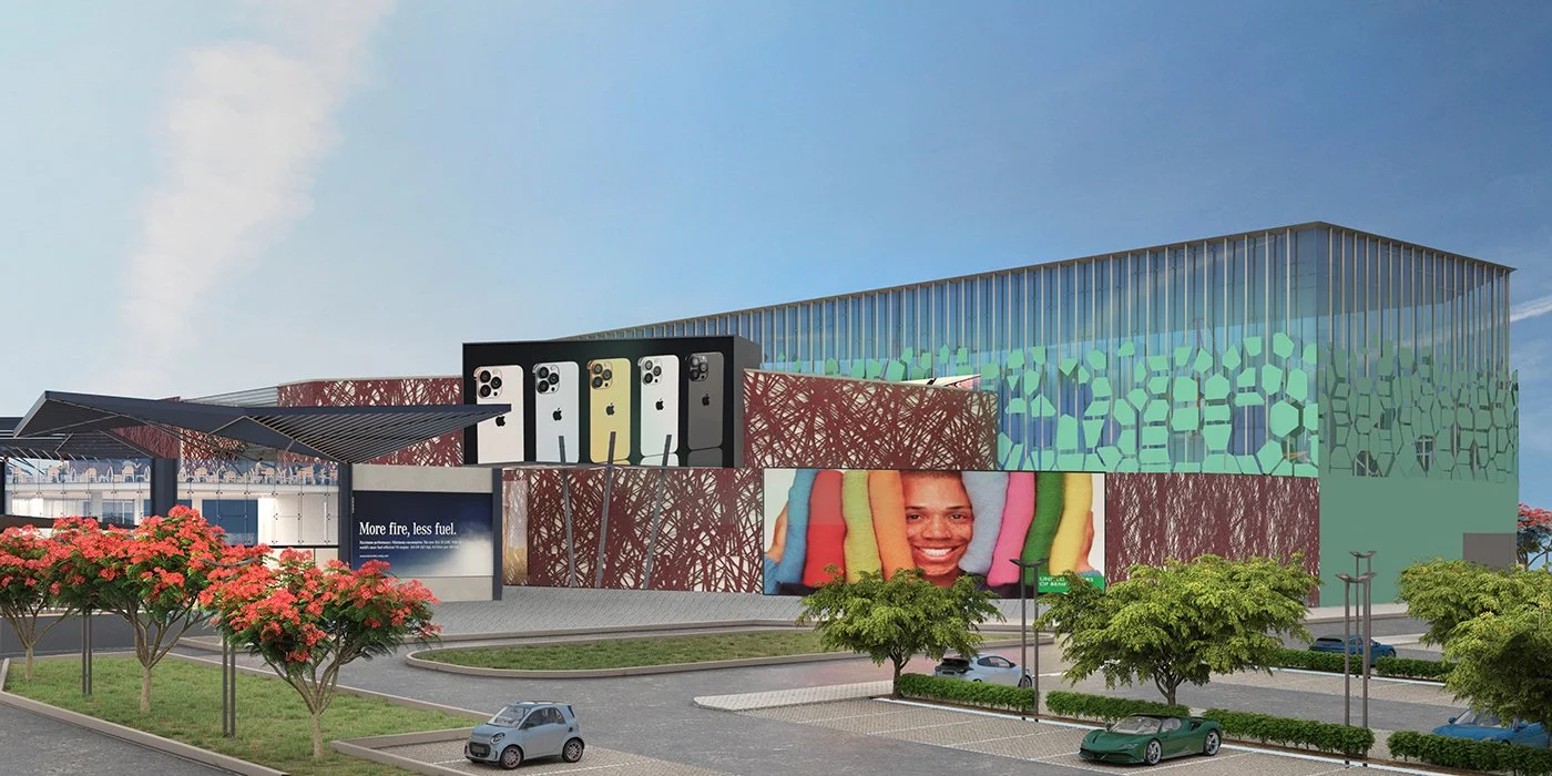 A modern building with iPhone 13 promotional signs, digital billboards, and colorful exterior architecture, surrounded by green trees and parked cars.