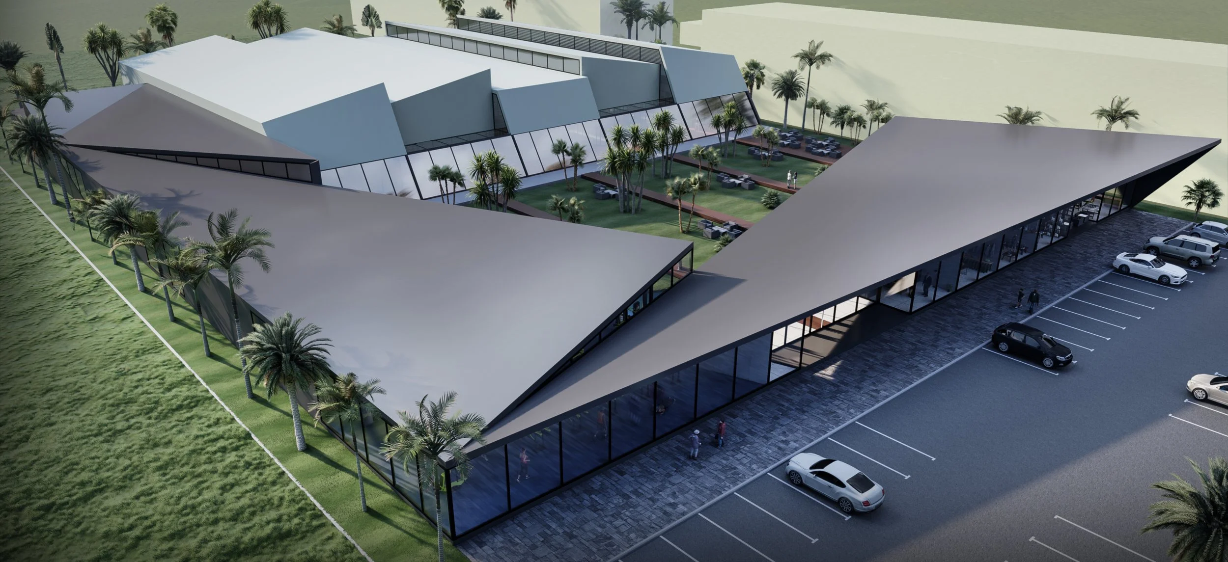 A modern architectural building with an outdoor seating area, surrounded by palm trees, and a parking lot with several cars.