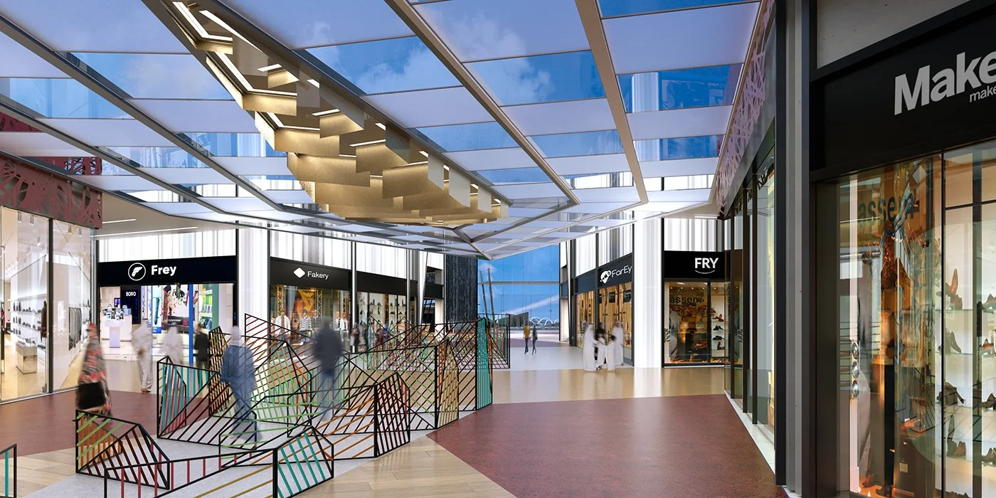 Interior of a modern shopping mall with stores, a glass ceiling, and a glass wall showing the sky.