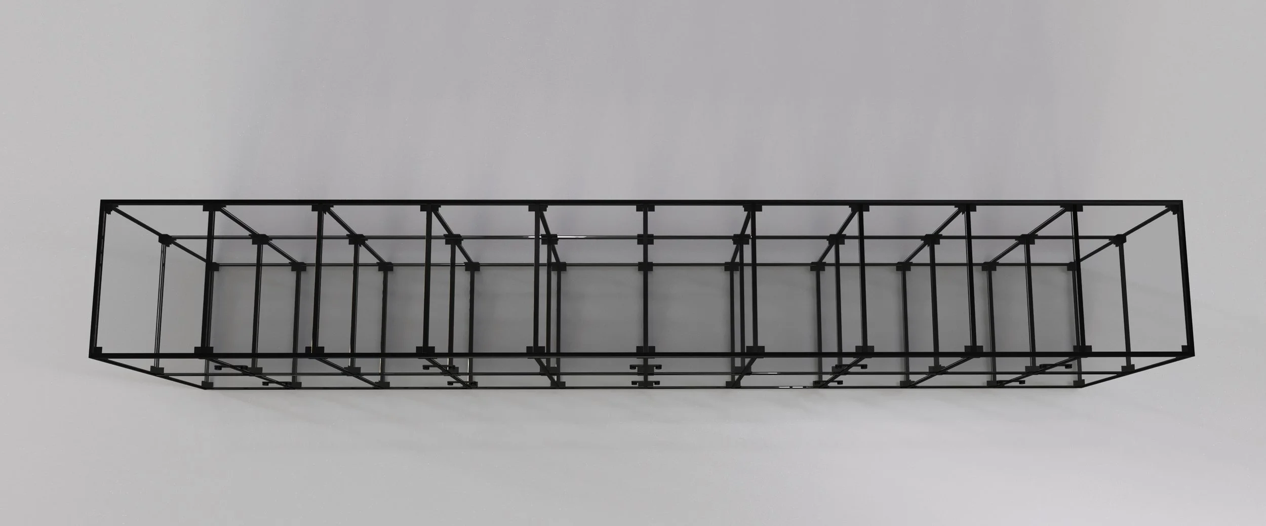 A black metal geometric structure resembling a rectangular frame with interconnected lines and supports, placed against a plain light gray background.